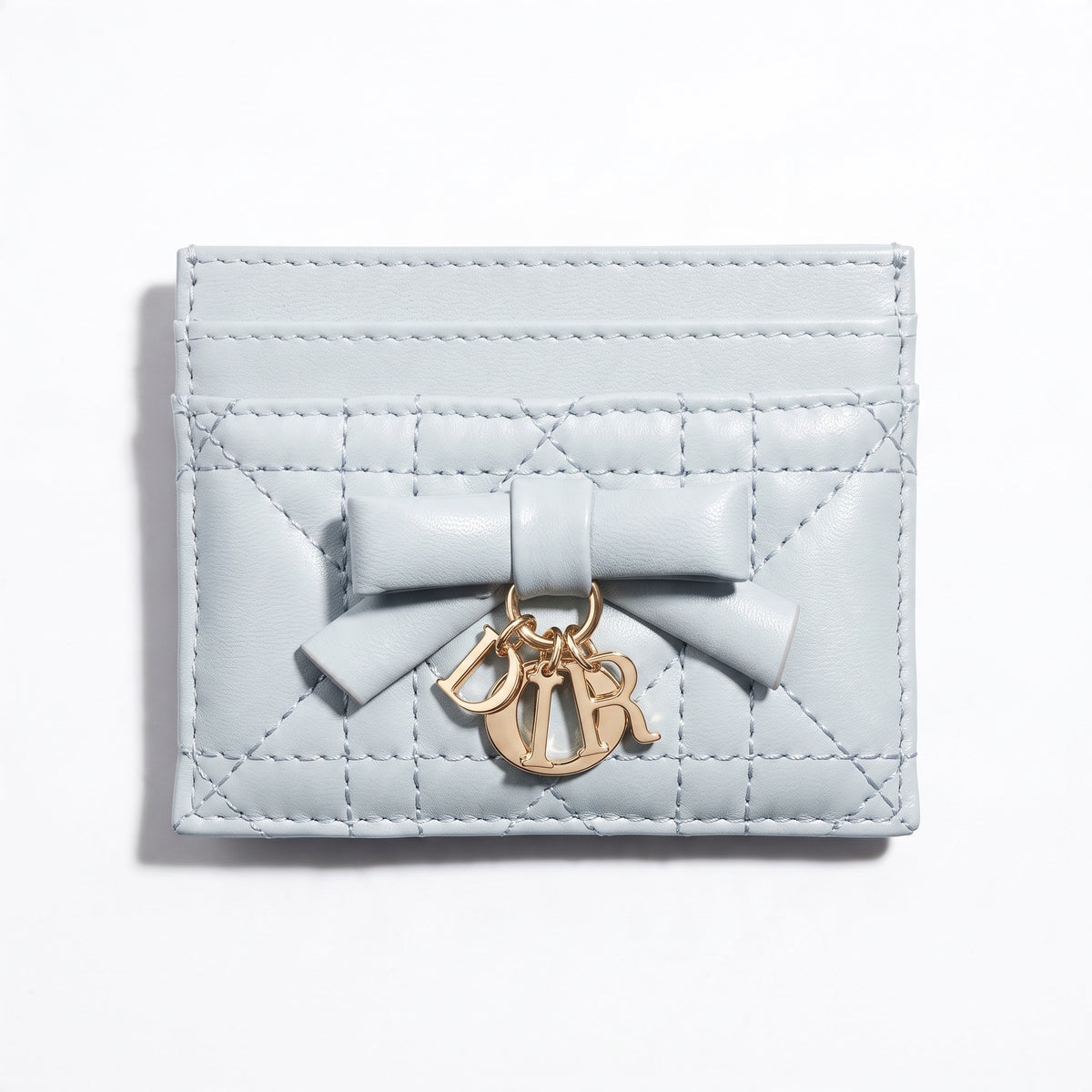 powder blue quilted Dior card holder with bow and gold letter charms