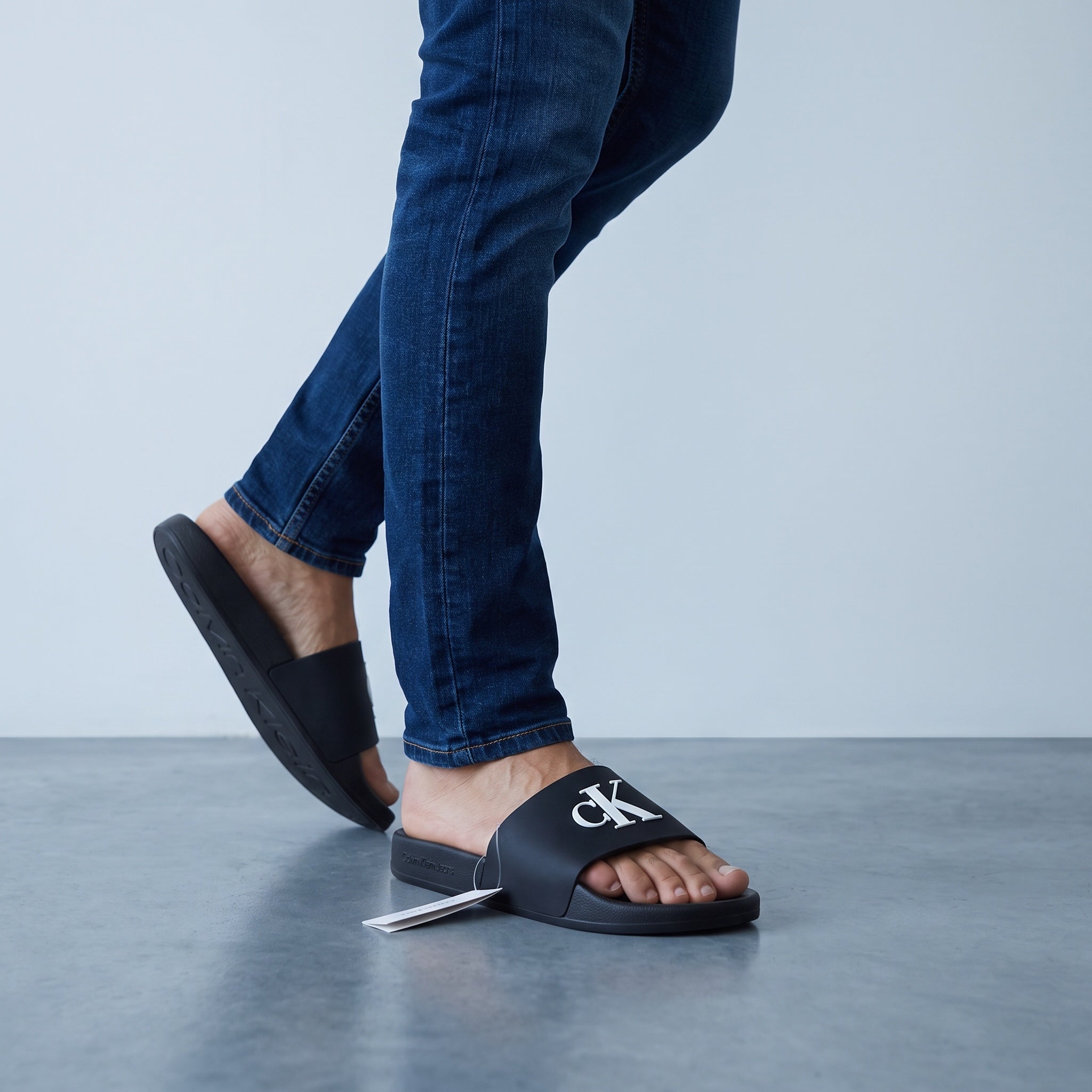 Black Calvin Klein men's slide sandals with raised CK logo