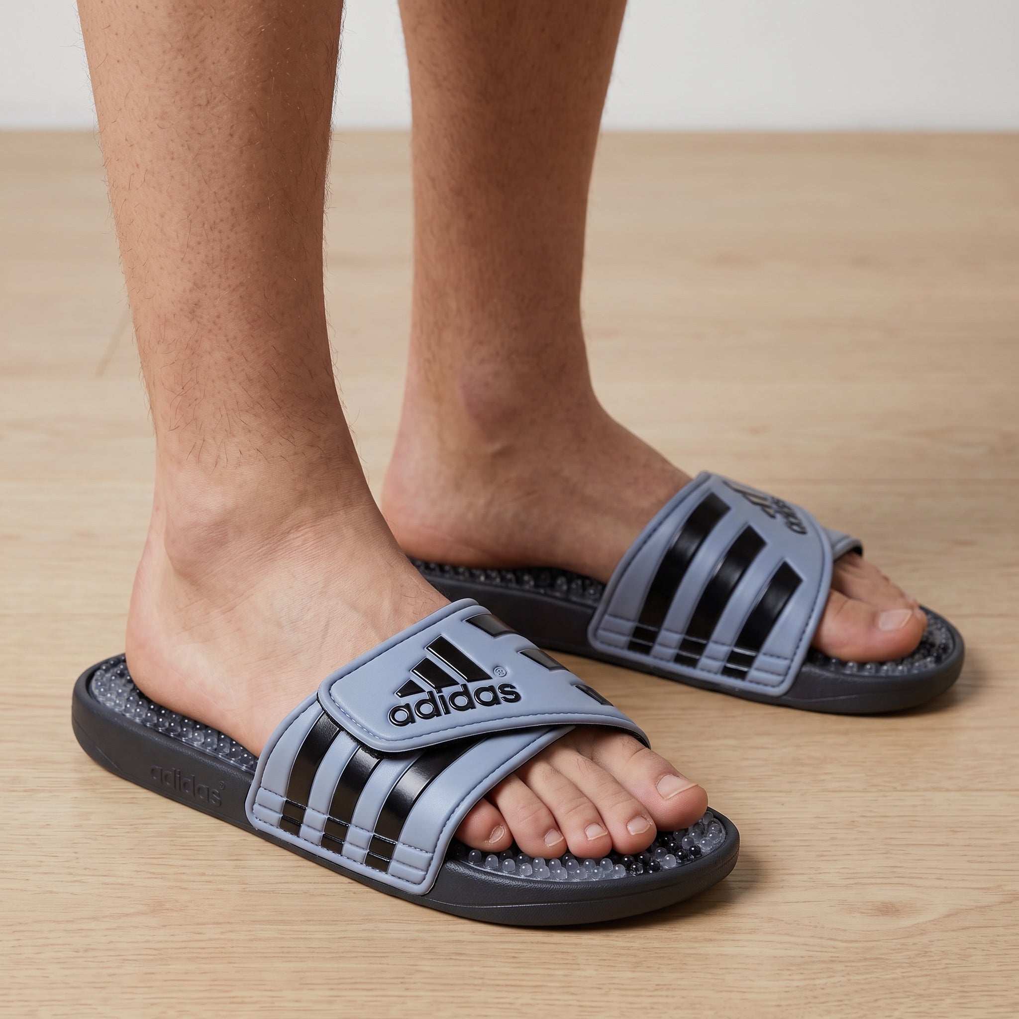 Adidas light blue and black three-stripe massage slides with beaded footbed