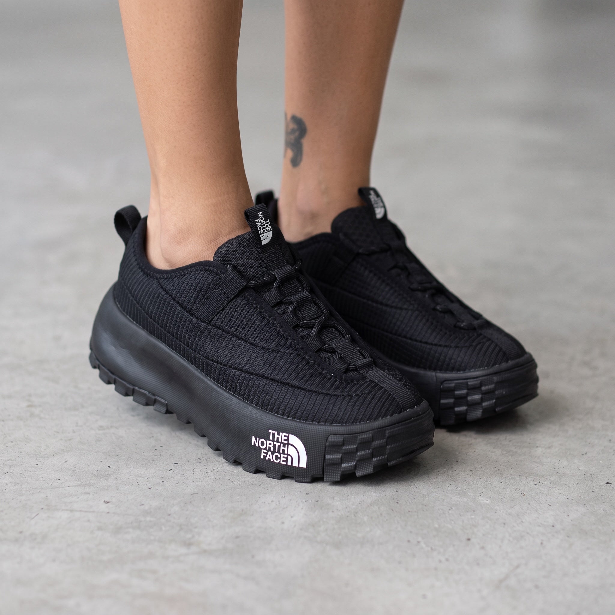 The North Face black trail sneaker with chunky lug sole and visible logo on midsole