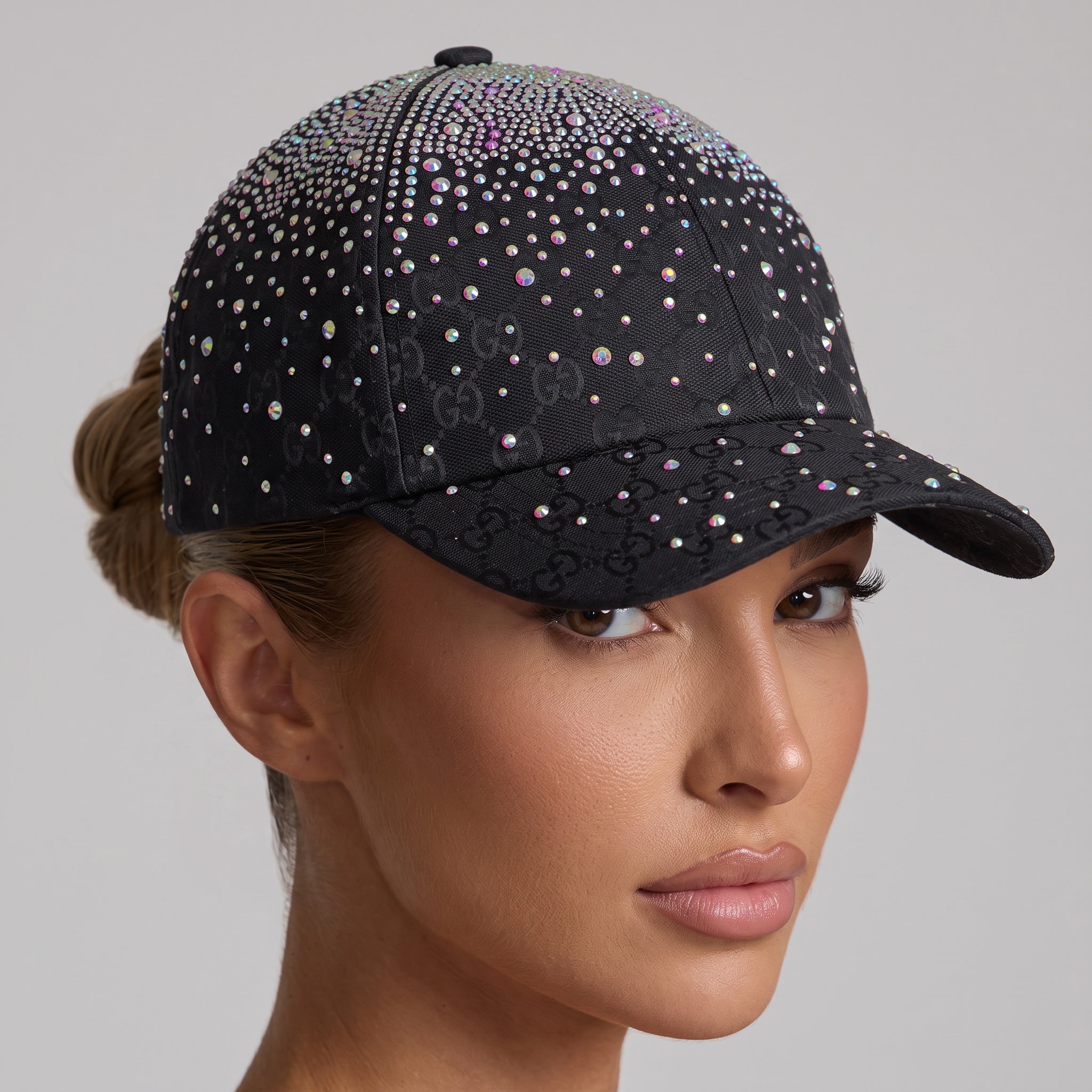 Black GG monogram baseball cap covered in iridescent crystals, worn by a model