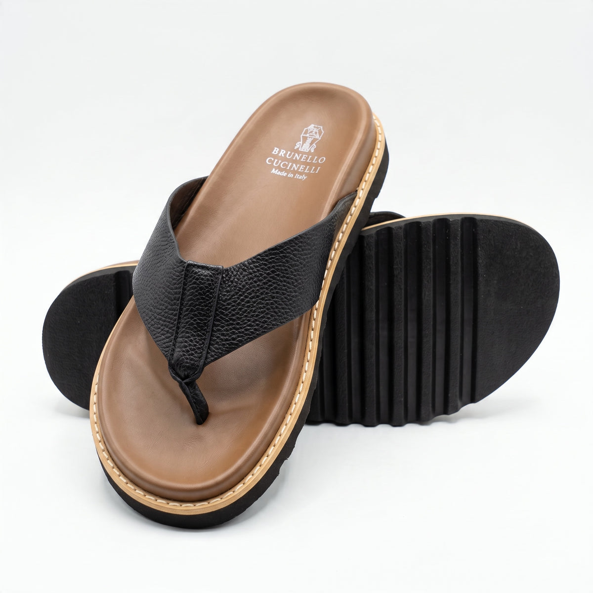 Brunello Cucinelli black textured thong sandal with brown footbed and ridged sole
