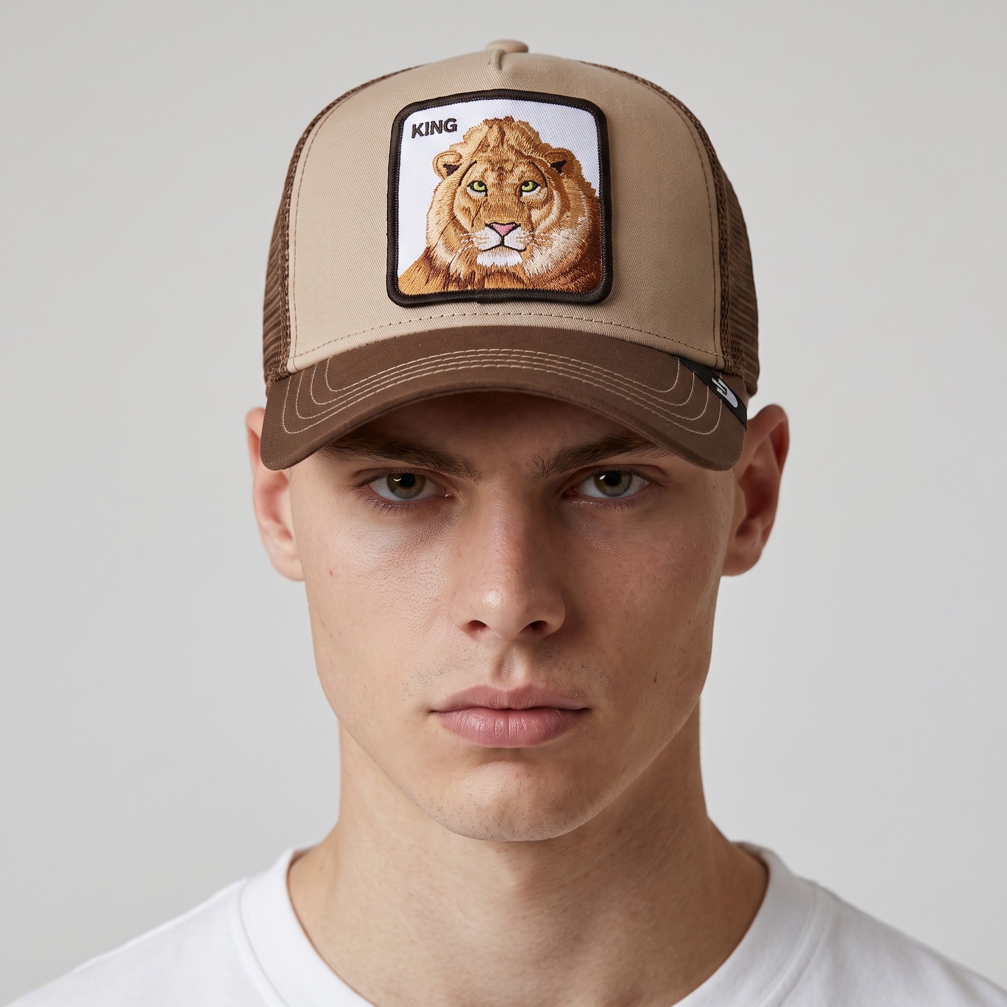 brown Goorin Bros trucker cap with embroidered lion patch reading KING