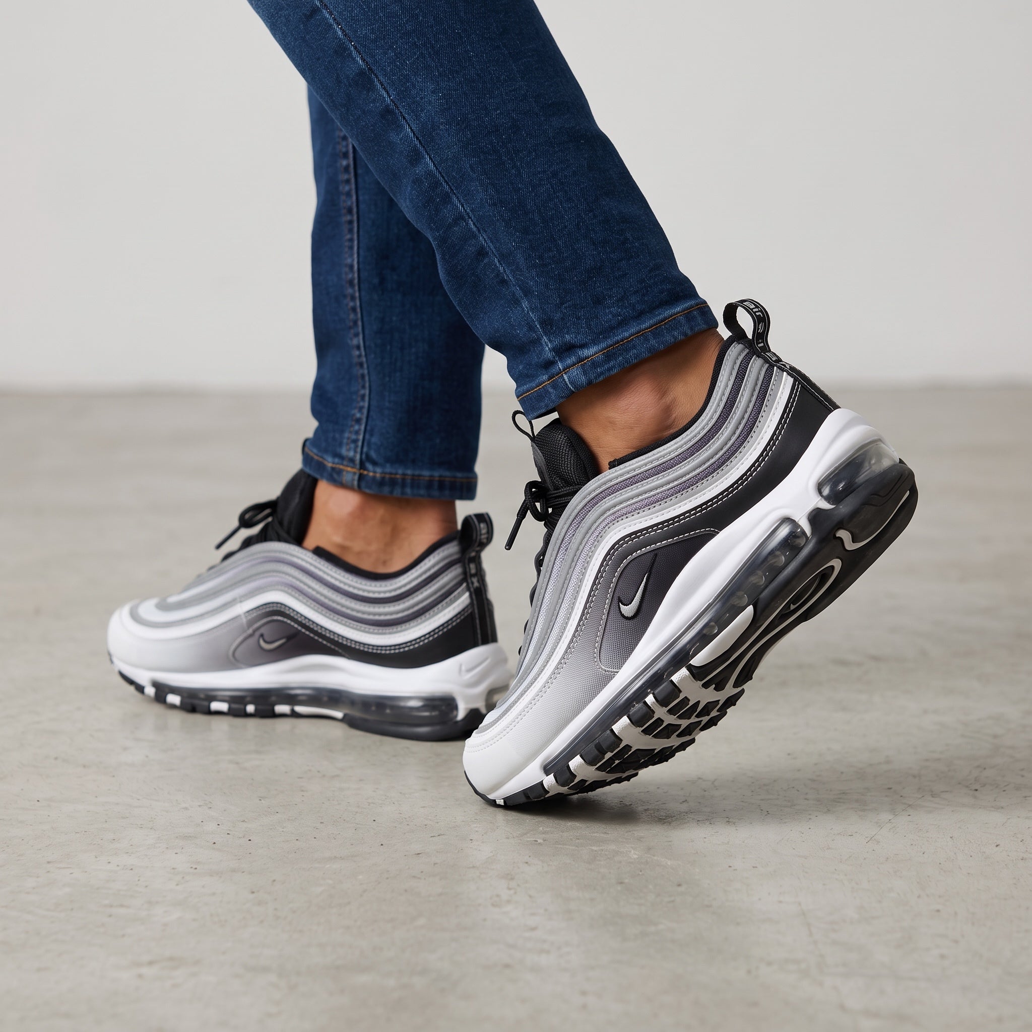 Nike Air Max 97 sneaker in silver, black and white showing wavy upper and full-length Air unit