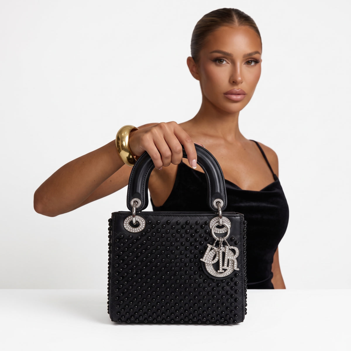 Black Dior Lady bag with studs and crystal Dior charms, top handles visible