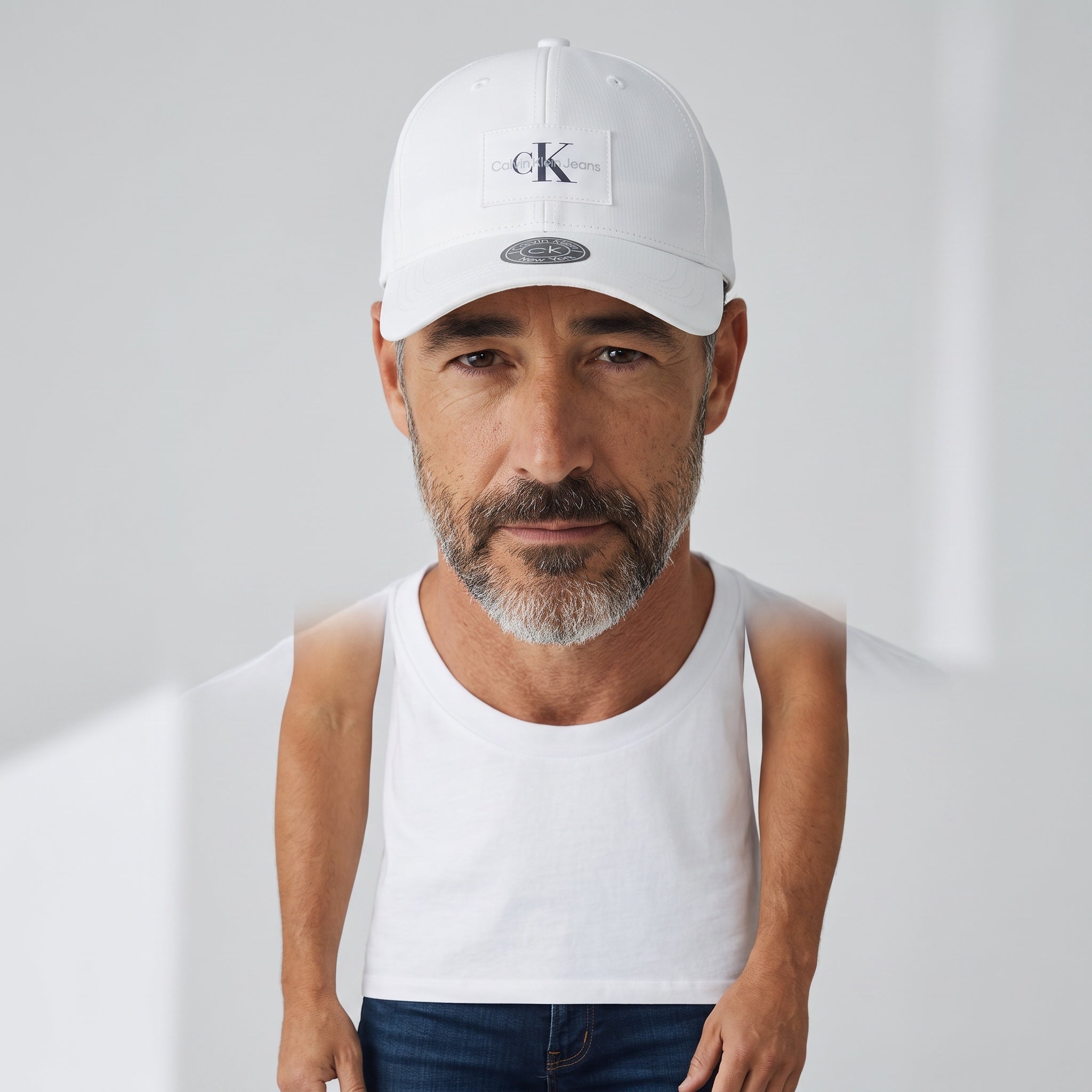 Man wearing a white Calvin Klein Jeans baseball cap with logo patch