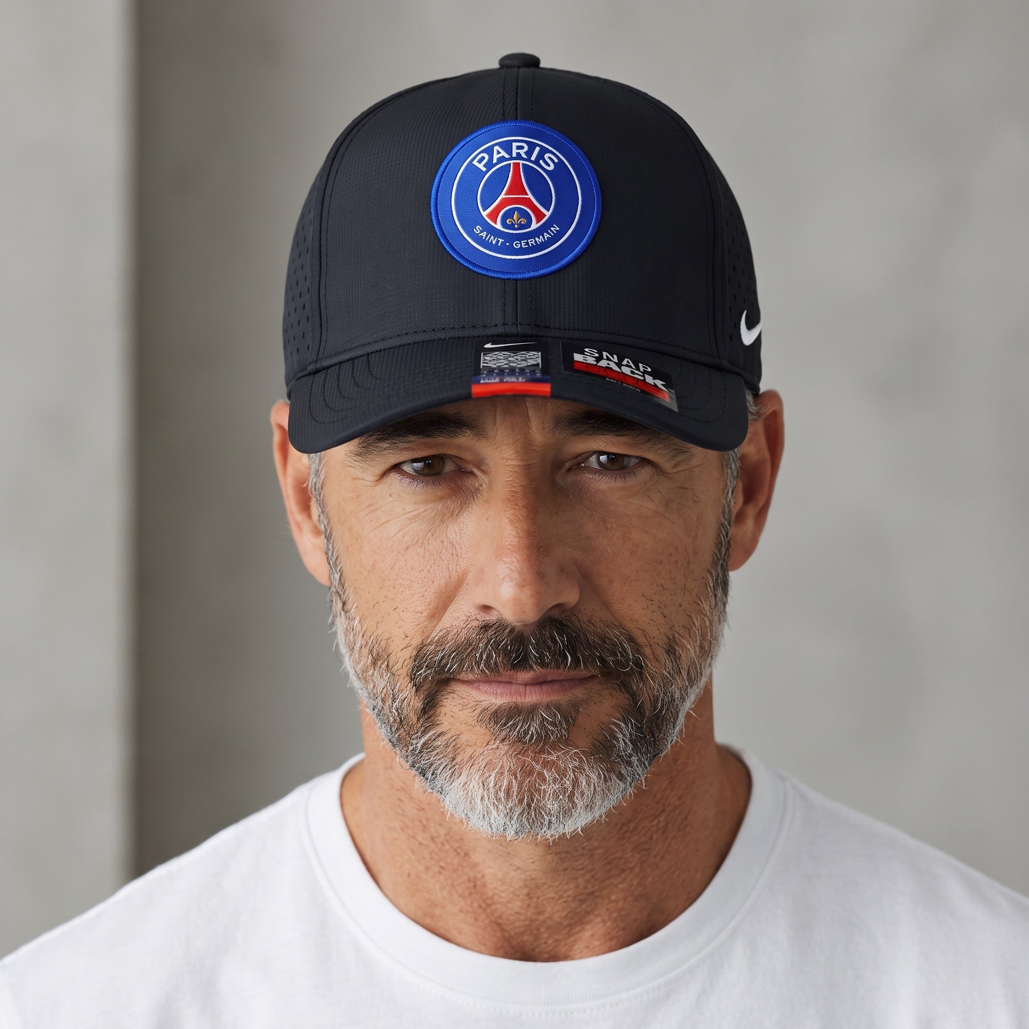 Man wearing a black Nike Paris Saint-Germain snapback cap with PSG crest