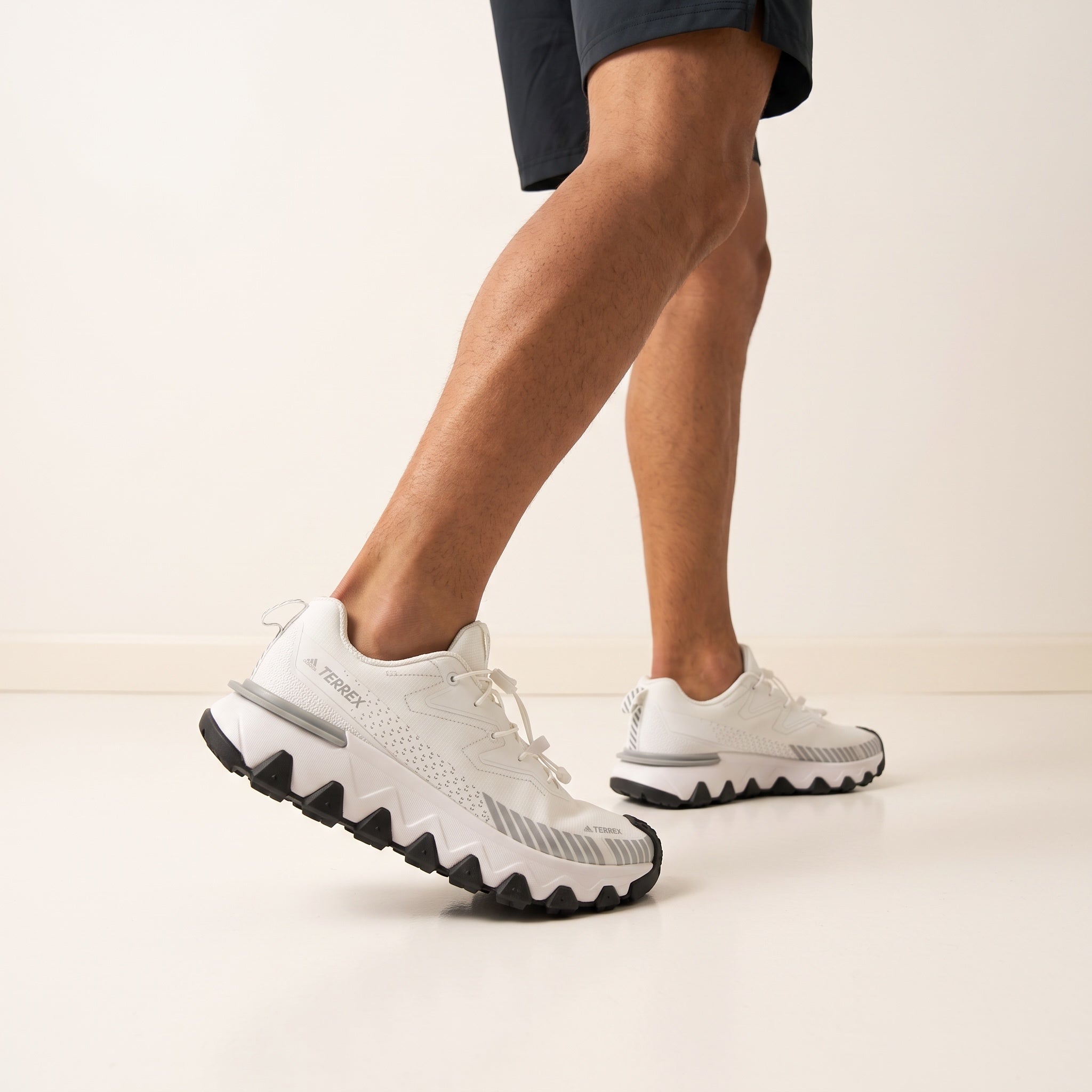 White Adidas Terrex trail sneaker with chunky lug sole and toggle laces
