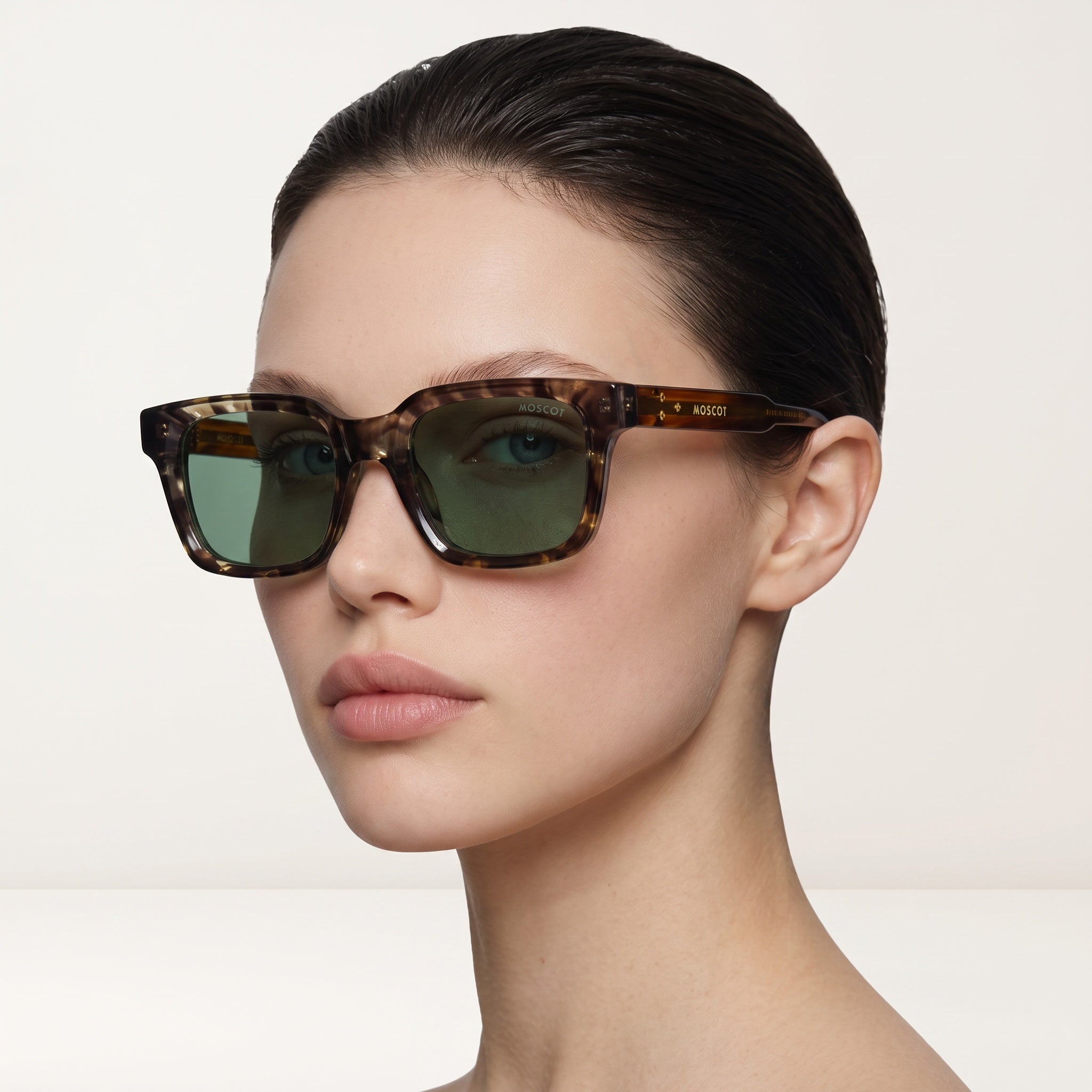 Moscot tortoise square sunglasses with green lenses on model