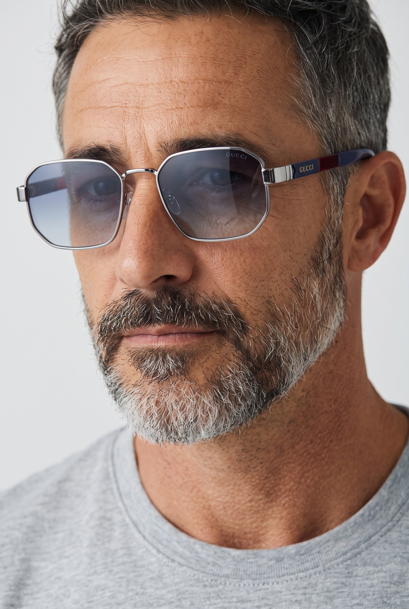 Silver-framed Gucci sunglasses with blue gradient lenses and navy-red temples