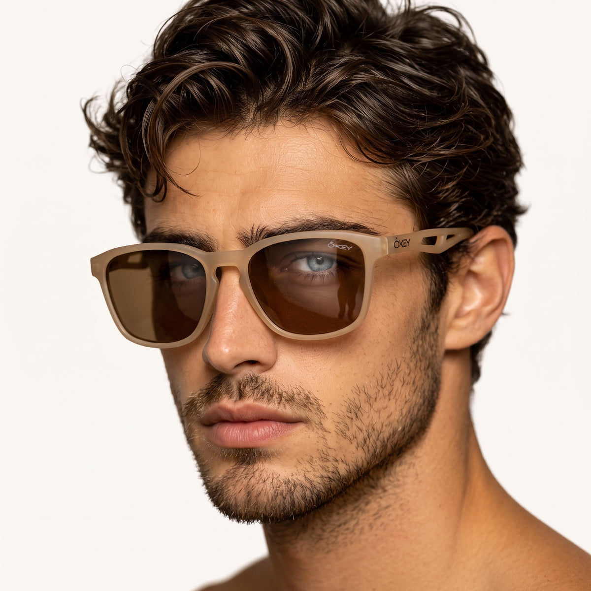 Close-up of man wearing ÖKEY matte taupe rectangular sunglasses with brown lenses