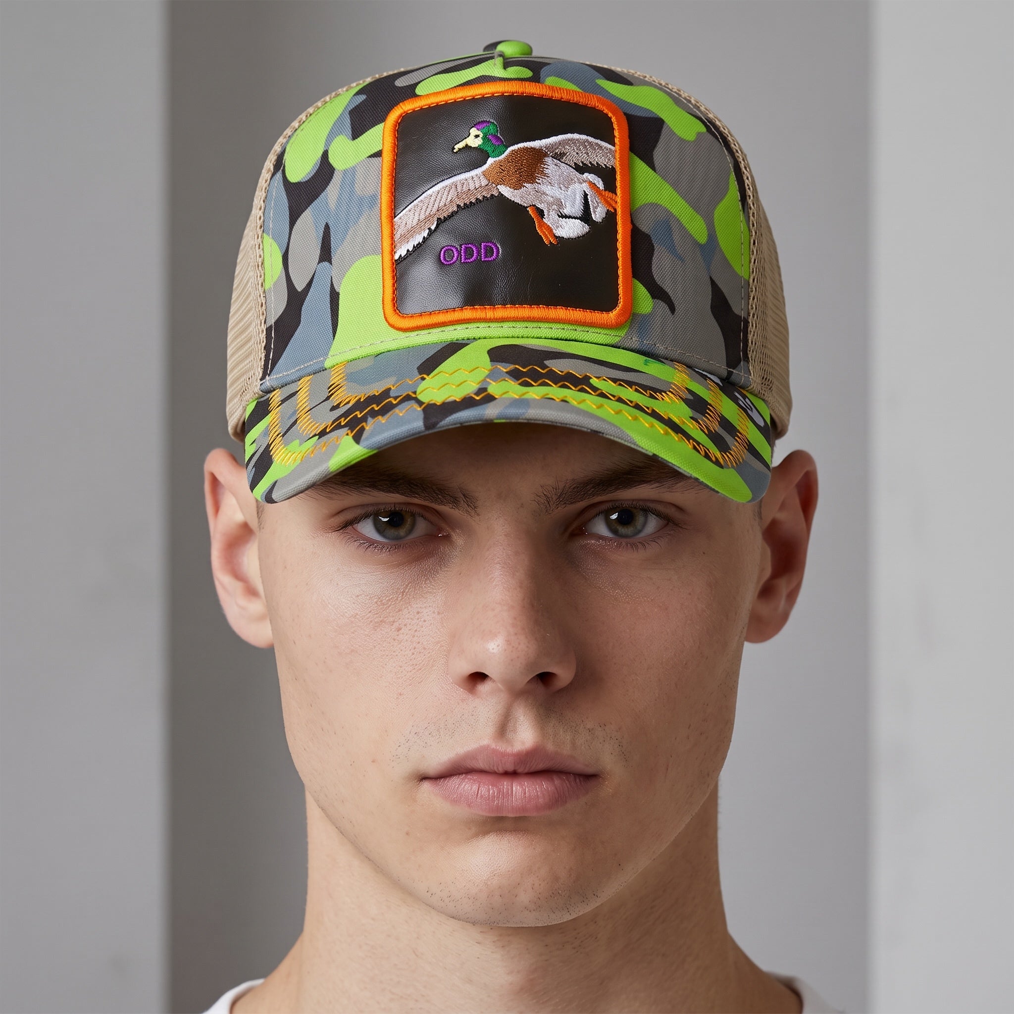 Front view neon camo trucker cap with embroidered flying duck patch and beige mesh back