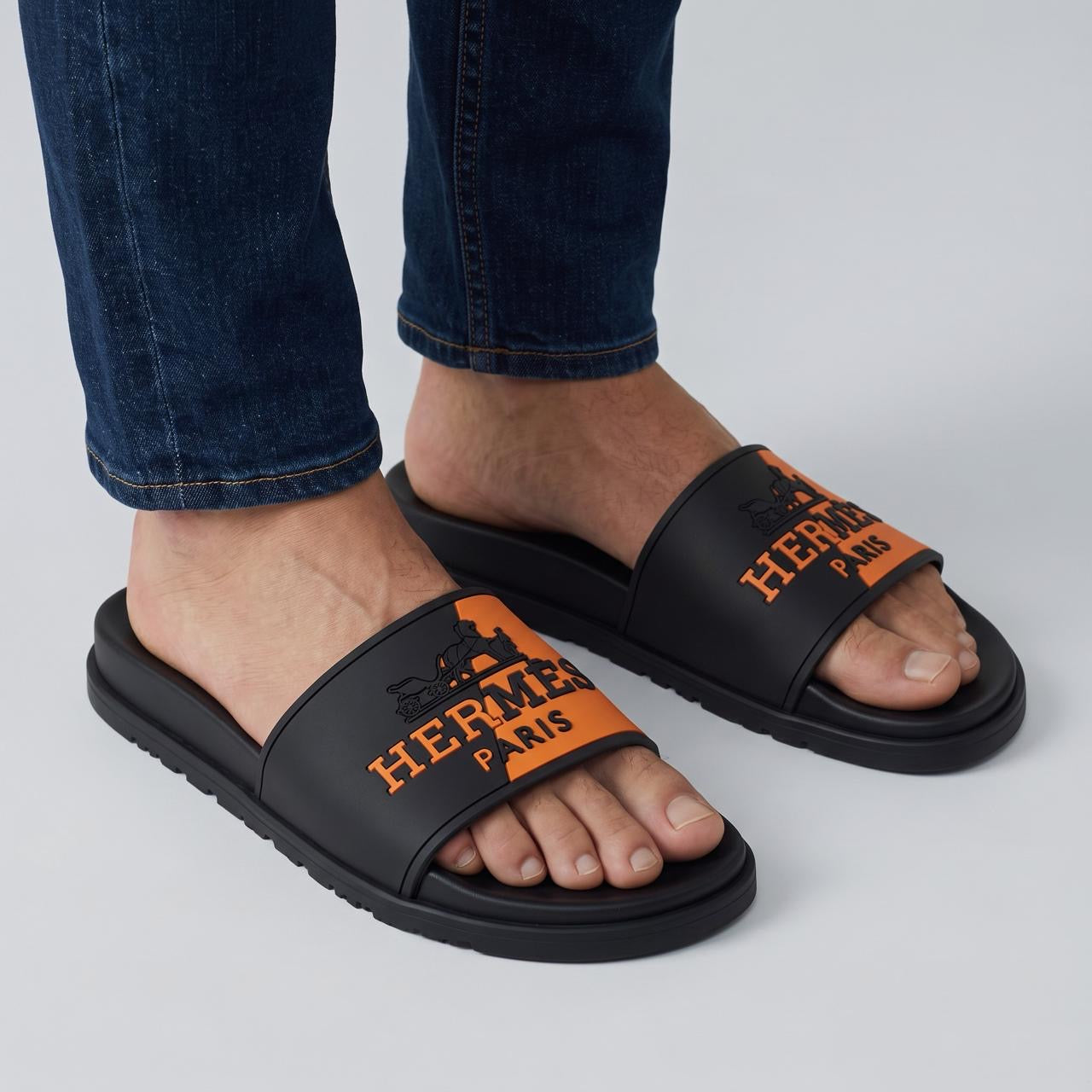 Hermès black and orange single-band pool slides on model feet