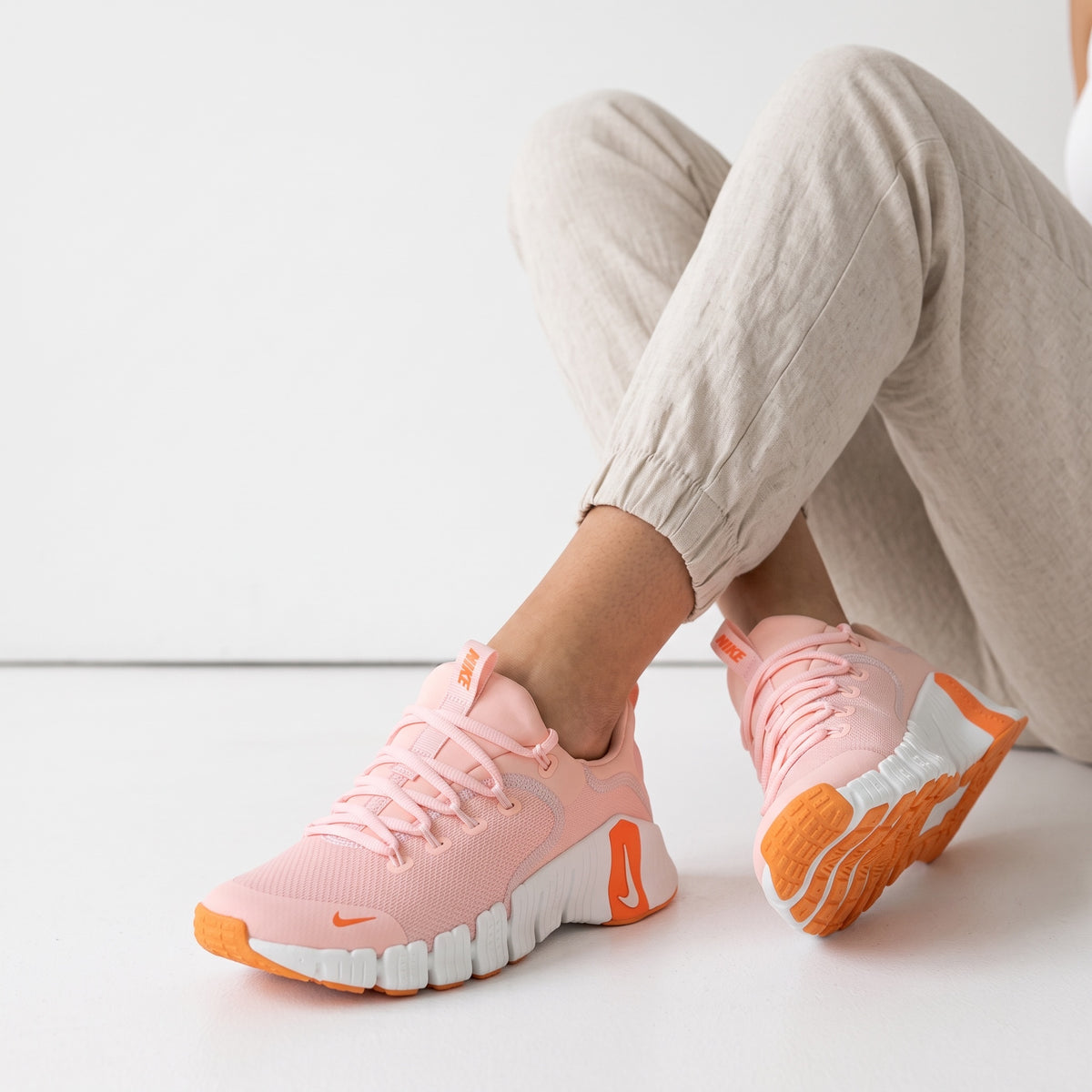 Pink Nike chunky sneakers with orange accents and white sole