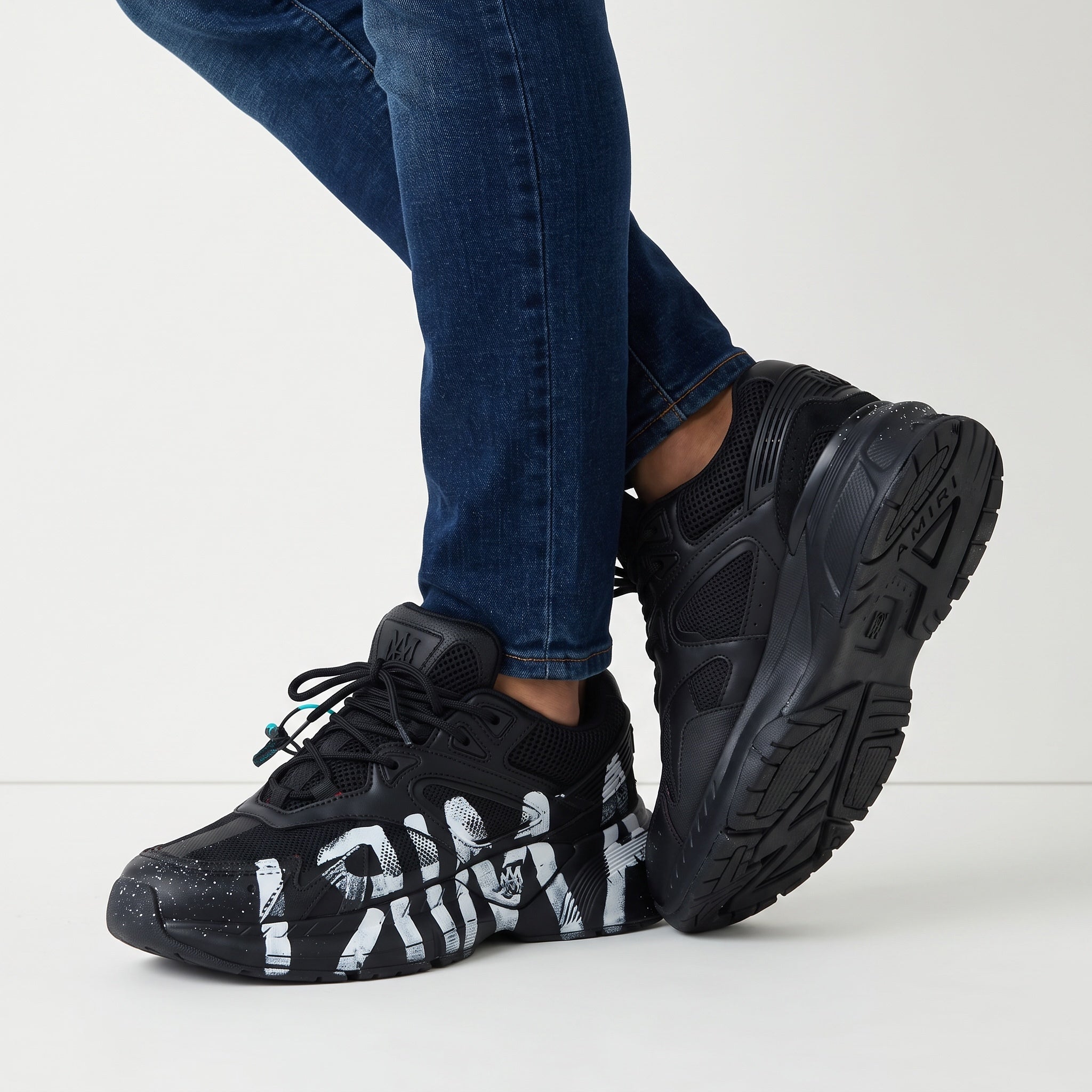 Black Amiri chunky sneakers with white painted graffiti on sole and upper