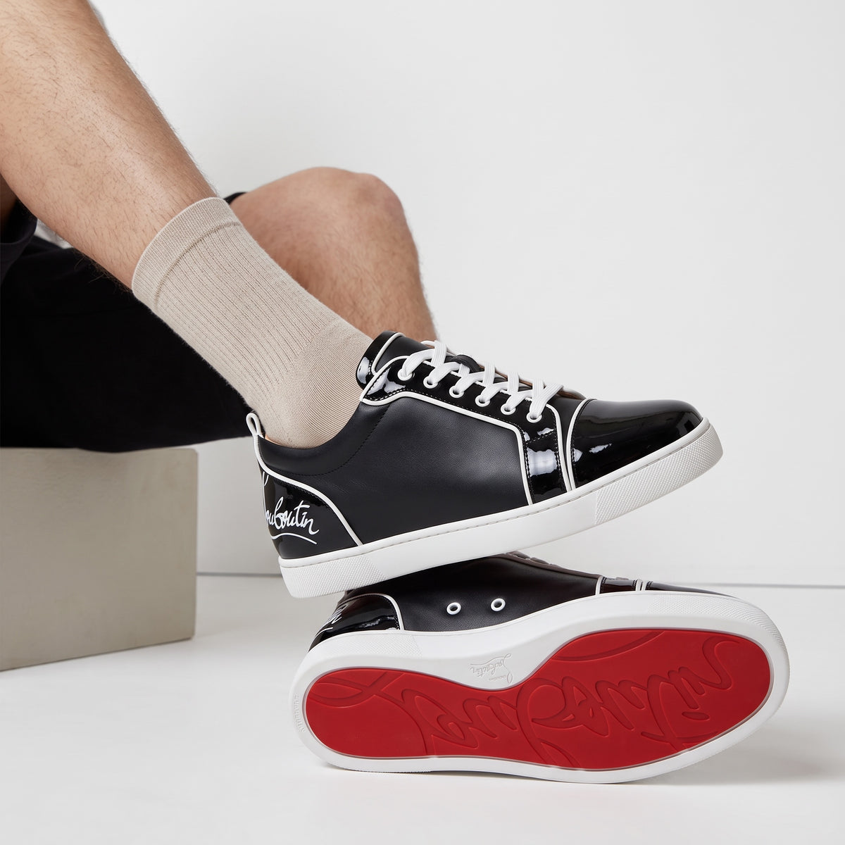 Christian Louboutin black low-top sneakers with red soles and white piping