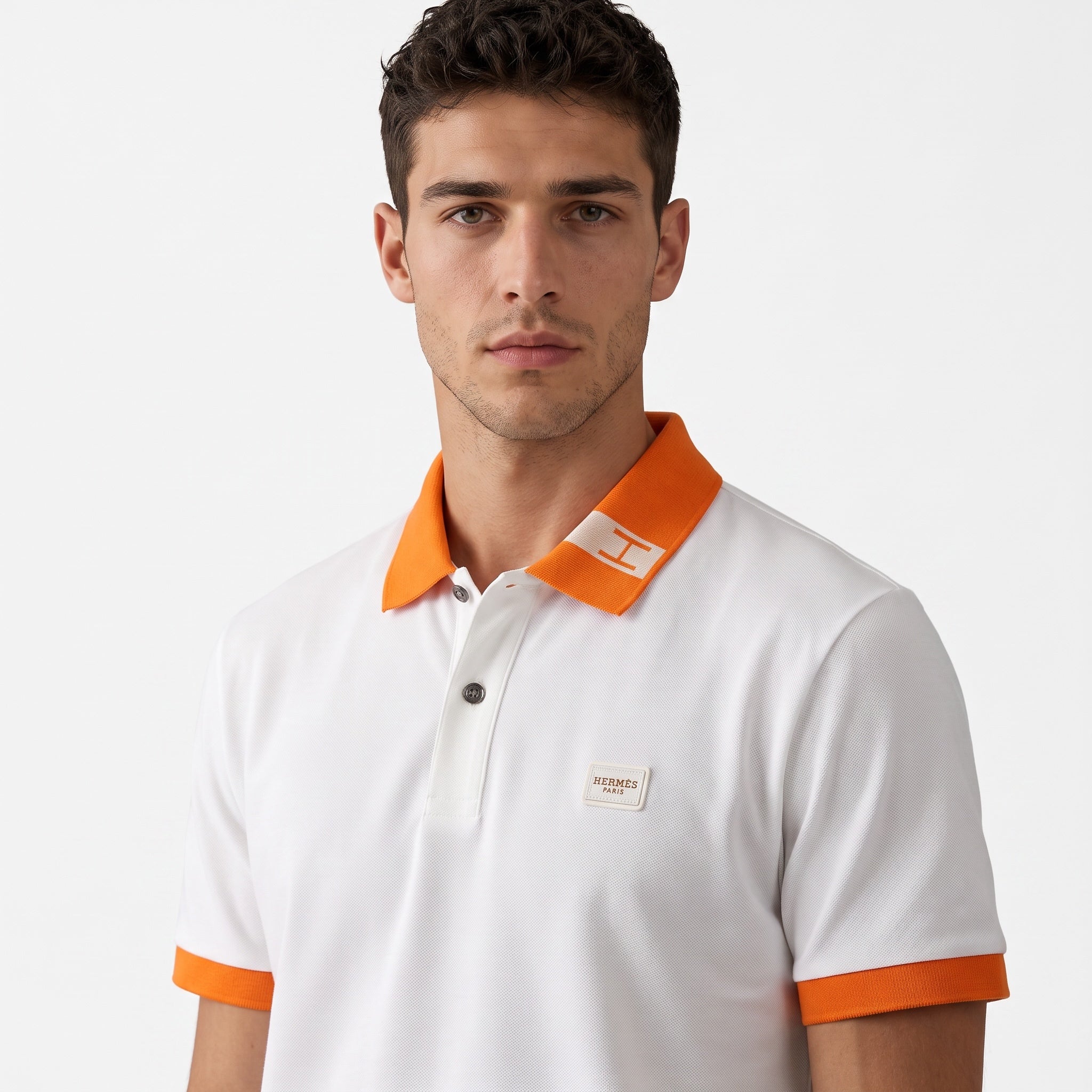 White Hermès polo with orange collar and orange sleeve cuffs, chest Hermès badge
