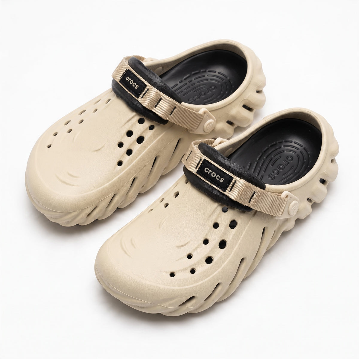Pair of sand beige Crocs clogs with black footbed and beige strap