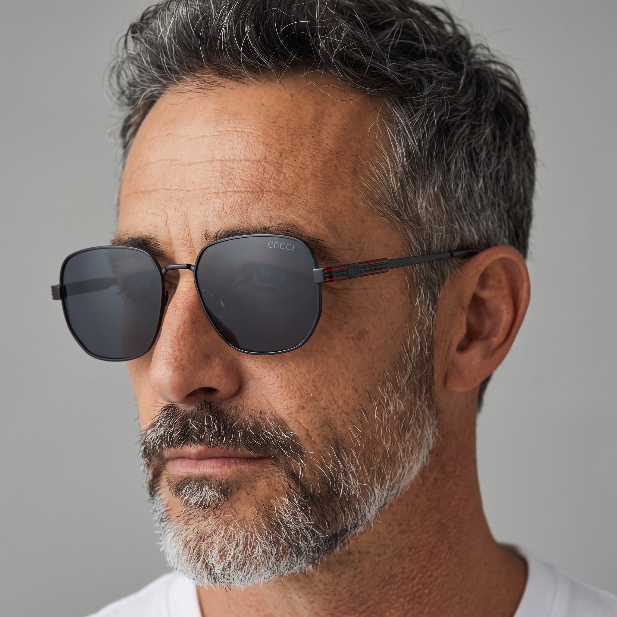 Close-up of man wearing matte black aviator sunglasses with dark lenses and striped temple