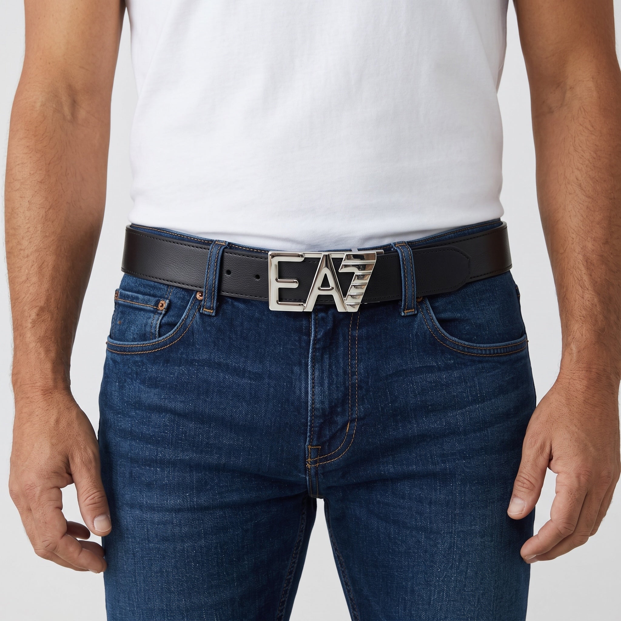 Black belt with silver EA7 buckle worn with blue jeans