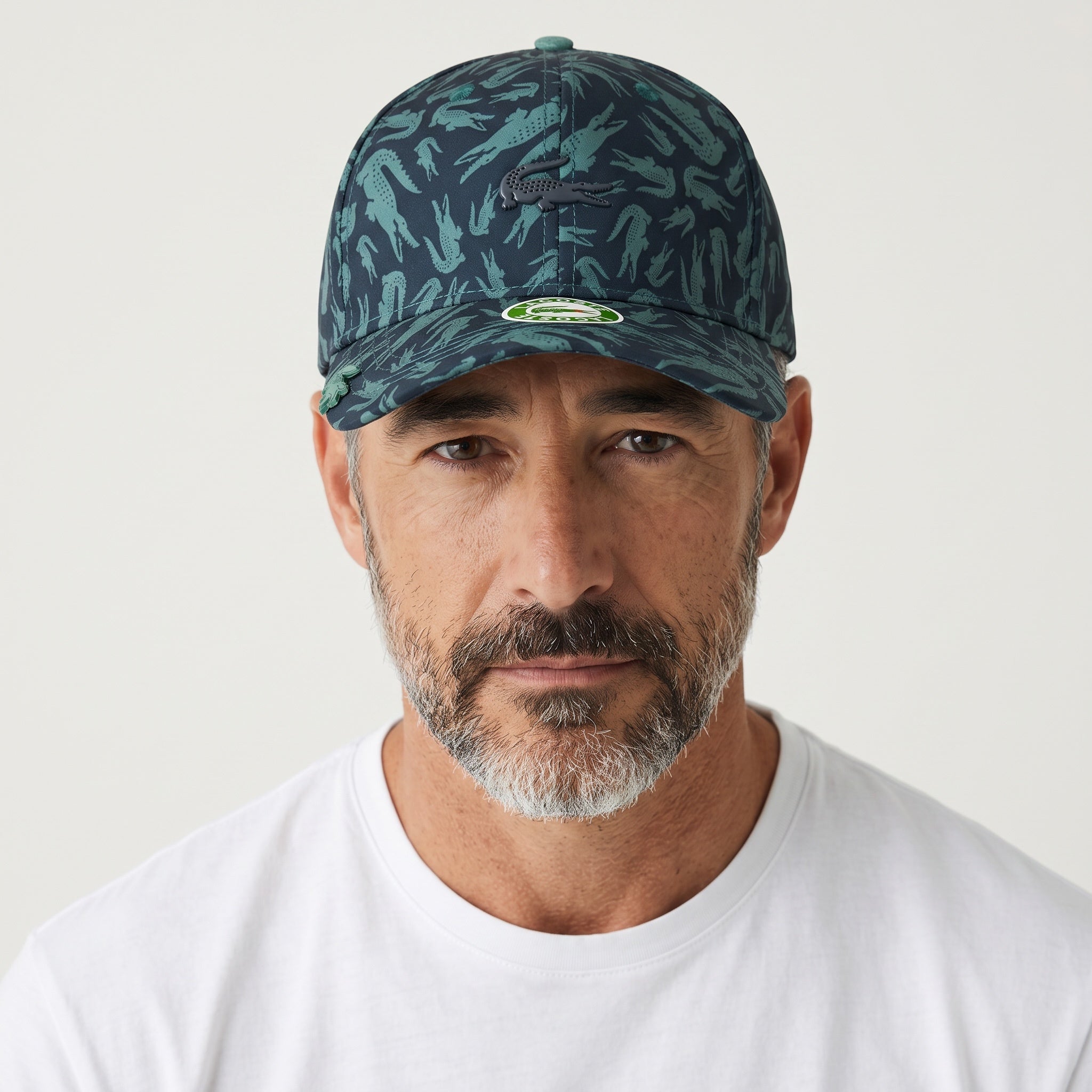 Man wearing a green and navy crocodile print Lacoste baseball cap