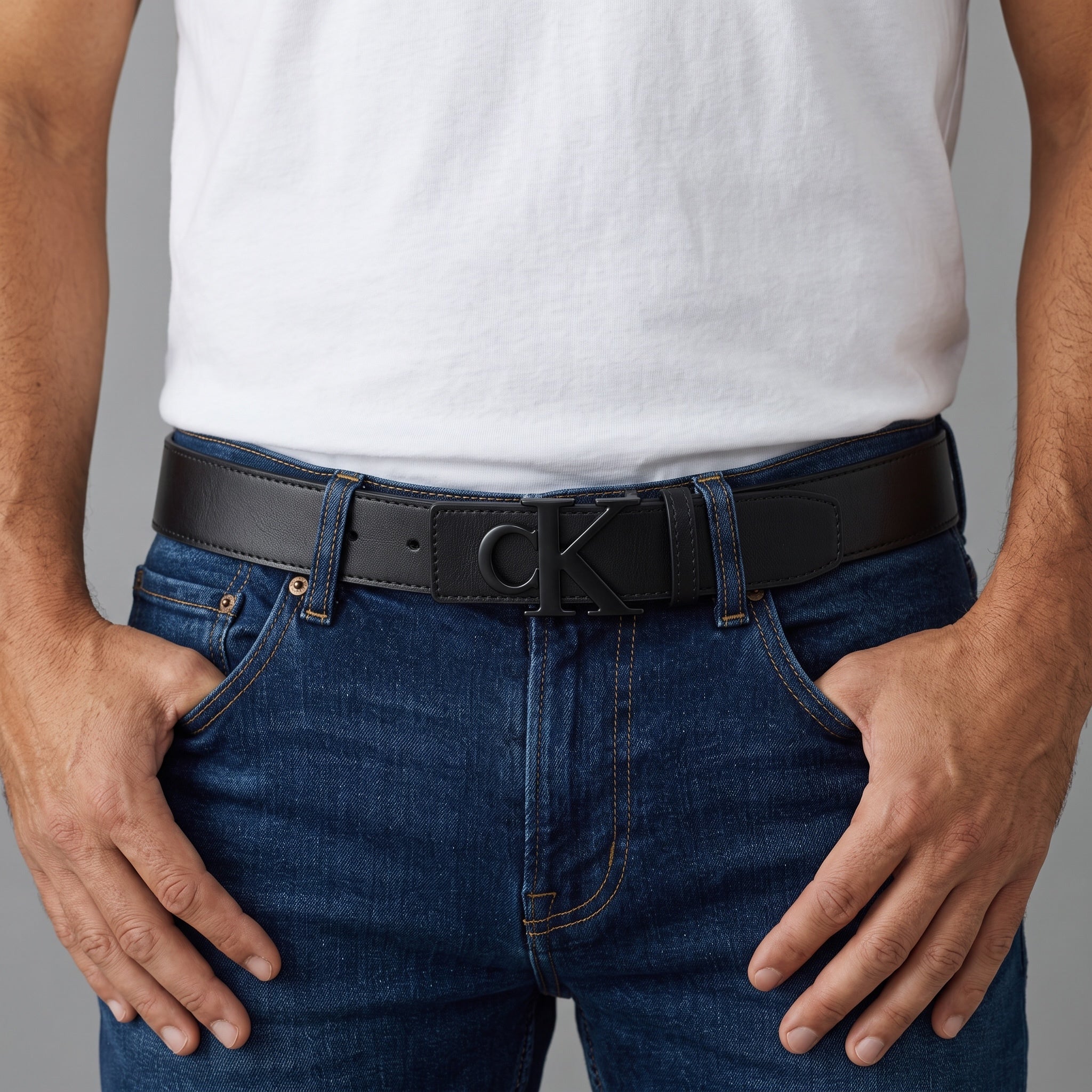 Men's black Calvin Klein belt with CK logo buckle worn with jeans