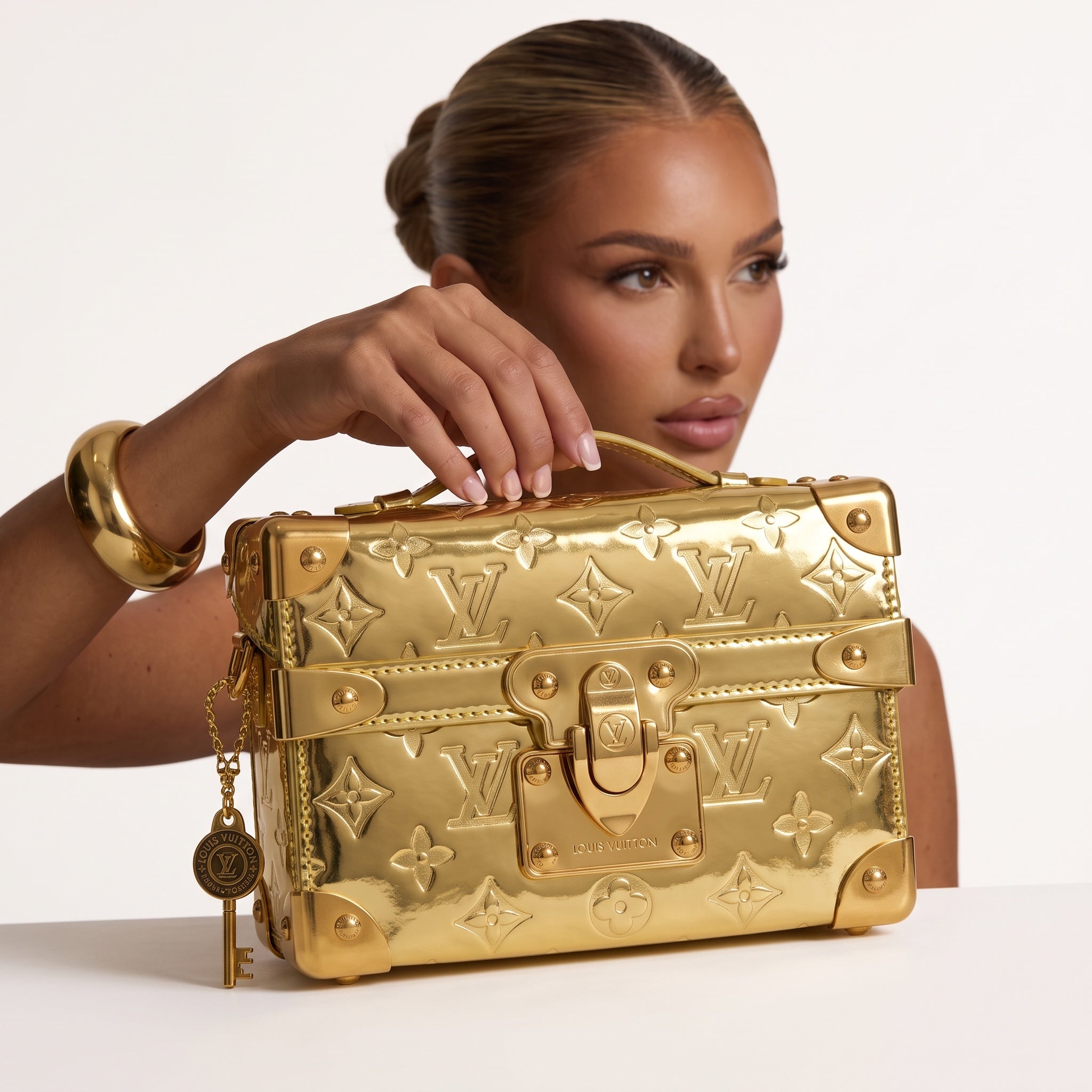 Gold Louis Vuitton Petite Malle mini trunk bag with top handle and embossed monogram