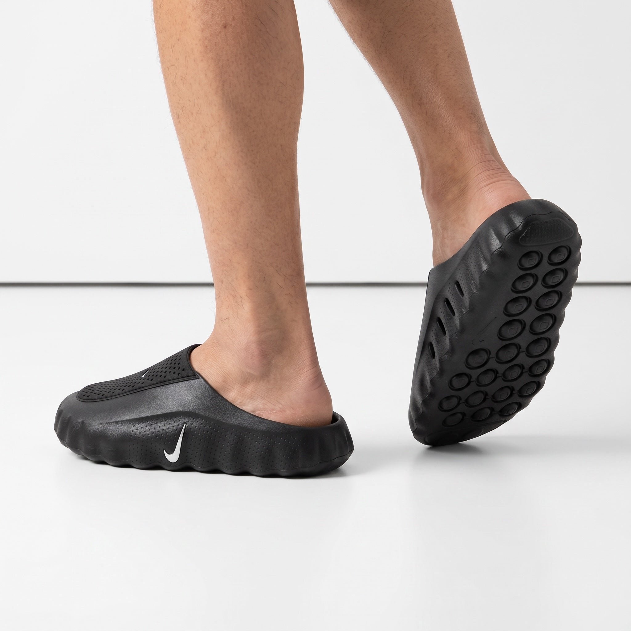 black Nike slip-on clog with perforated upper and white Swoosh