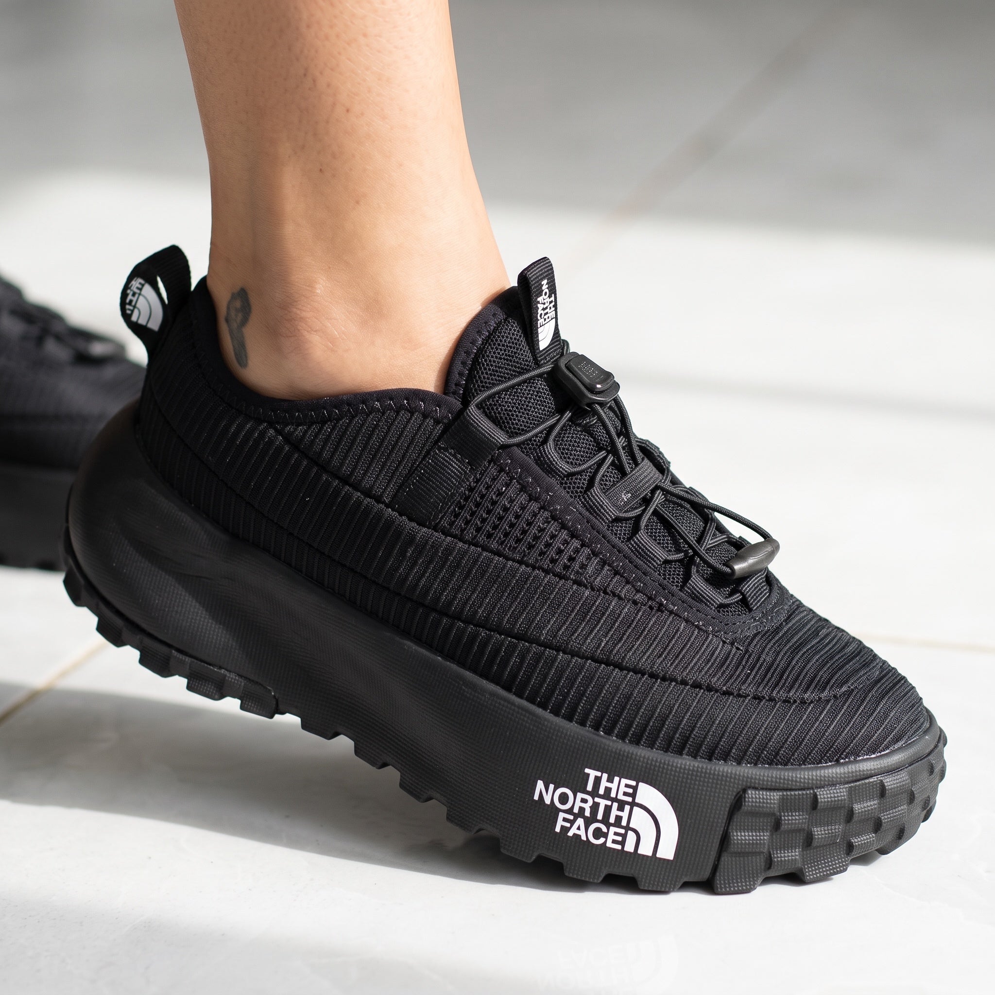 The North Face black trail sneaker with chunky lug sole and visible logo on midsole