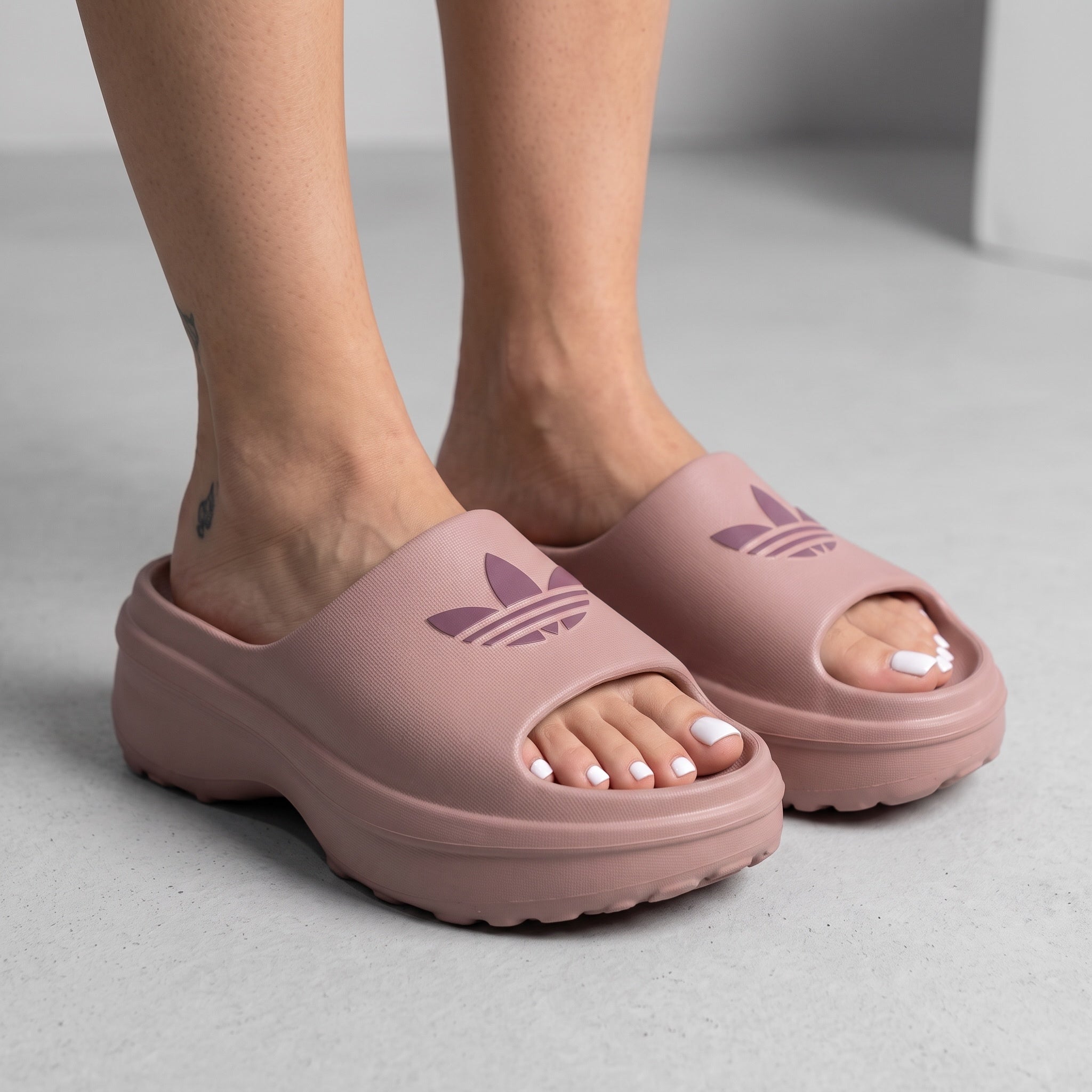 blush pink Adidas platform slide with embossed trefoil logo
