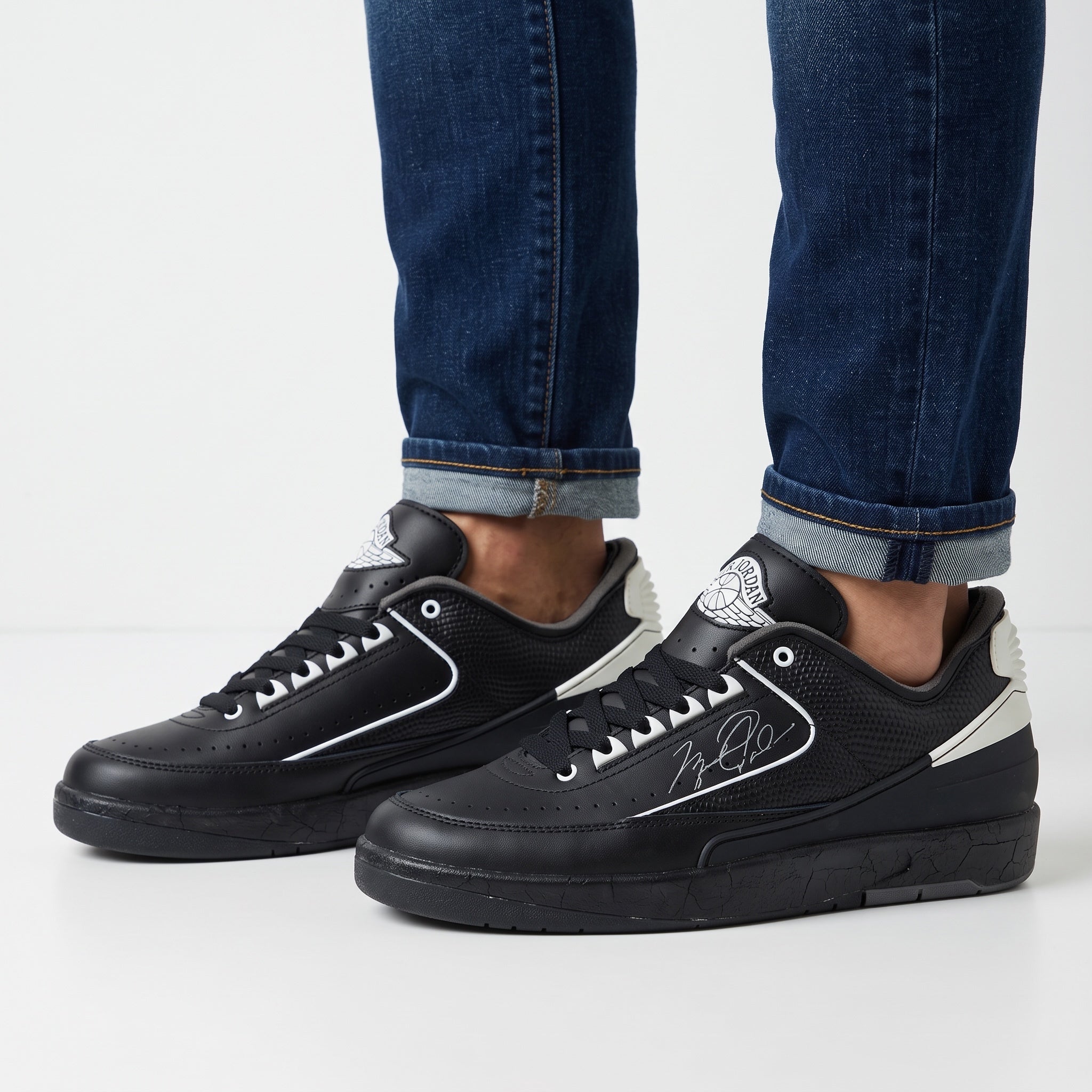 Black Jordan low-top trainers with white accents and signature side graphic