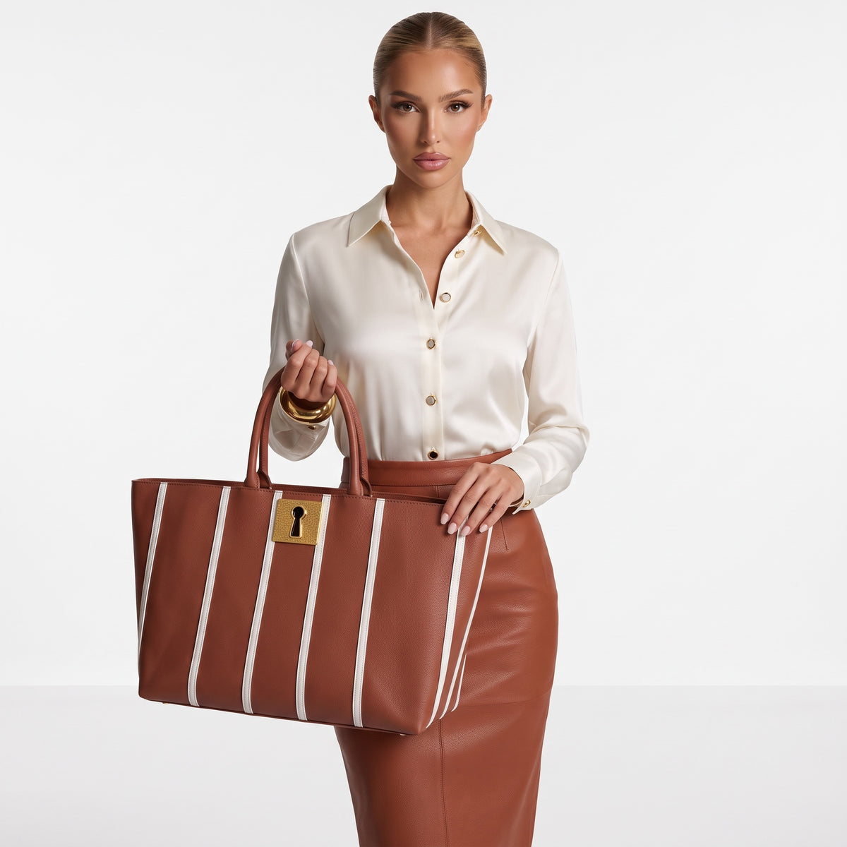 Brown Schiaparelli tote bag with white vertical stripes and gold keyhole plaque, shown with rolled top handles