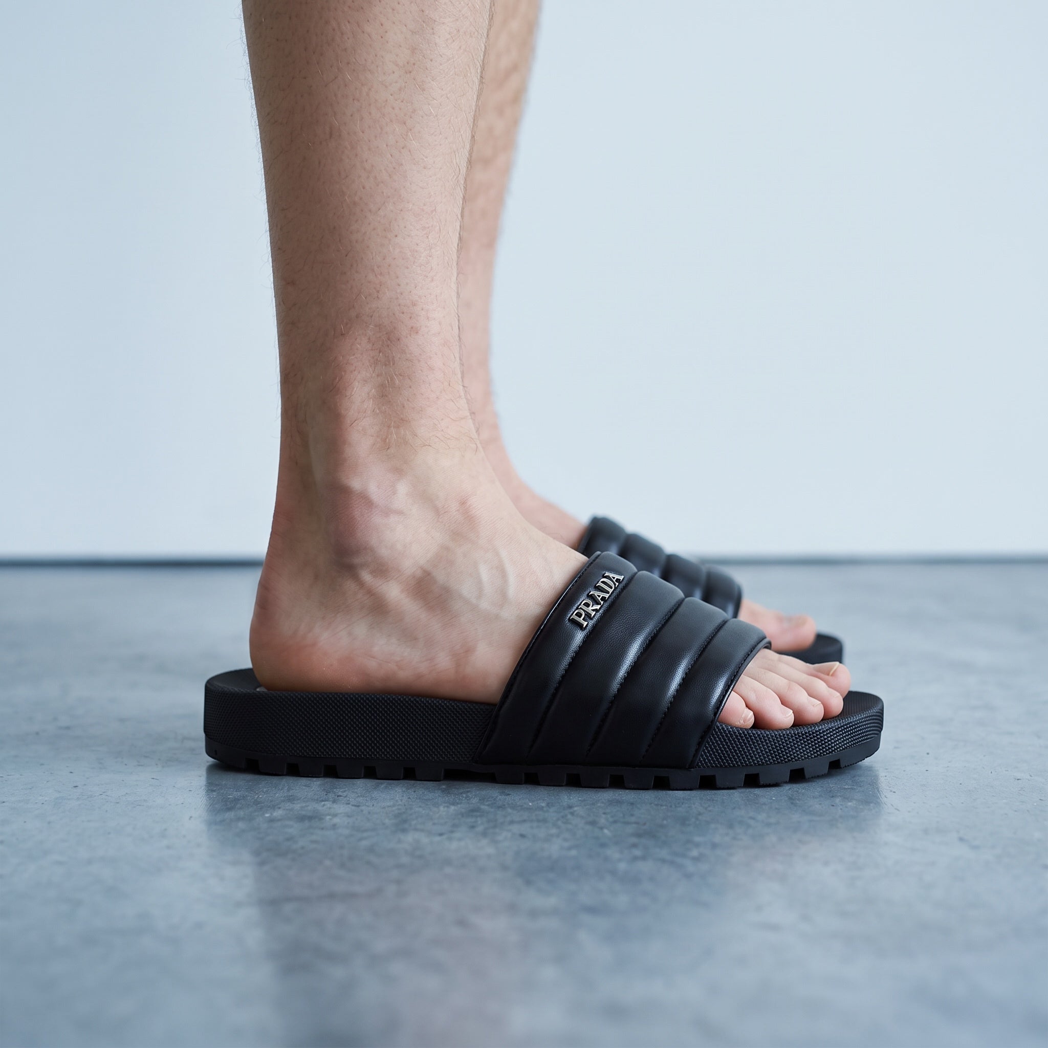 Black Prada padded platform slide sandals with metal logo on strap