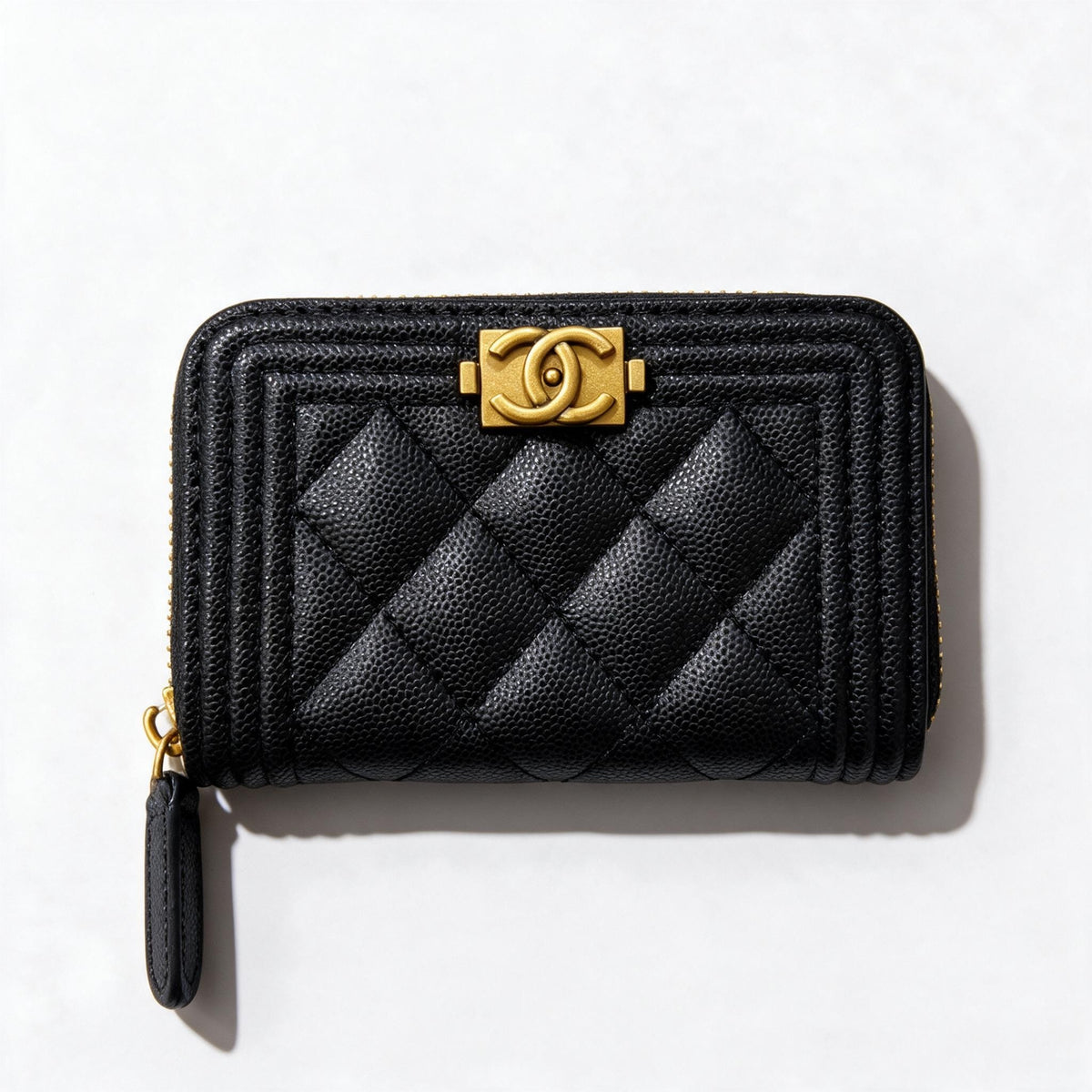 Black quilted Chanel zip wallet with gold CC clasp and wristlet strap