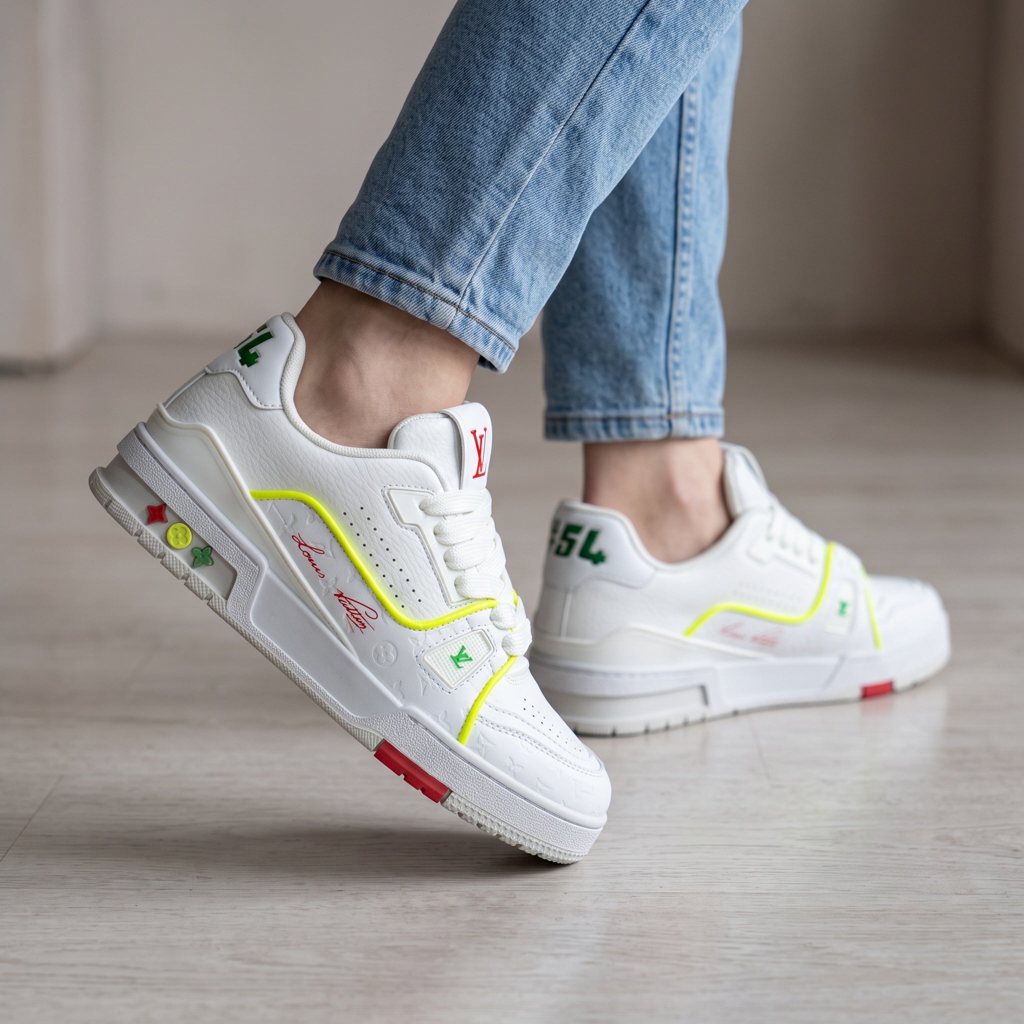 White Louis Vuitton low-top sneakers with neon yellow trim and embossed monogram
