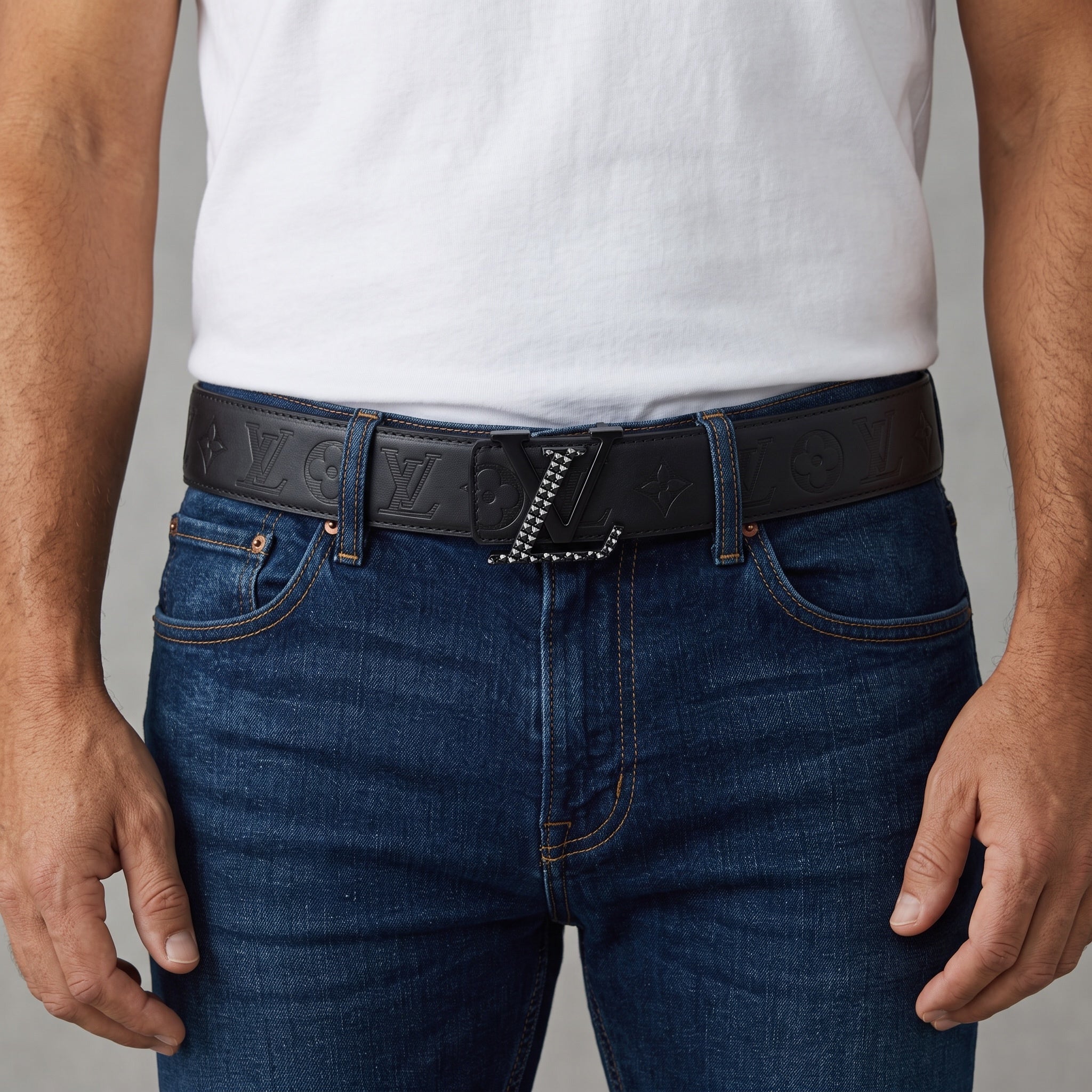Black Louis Vuitton embossed monogram belt with studded LV buckle worn with jeans