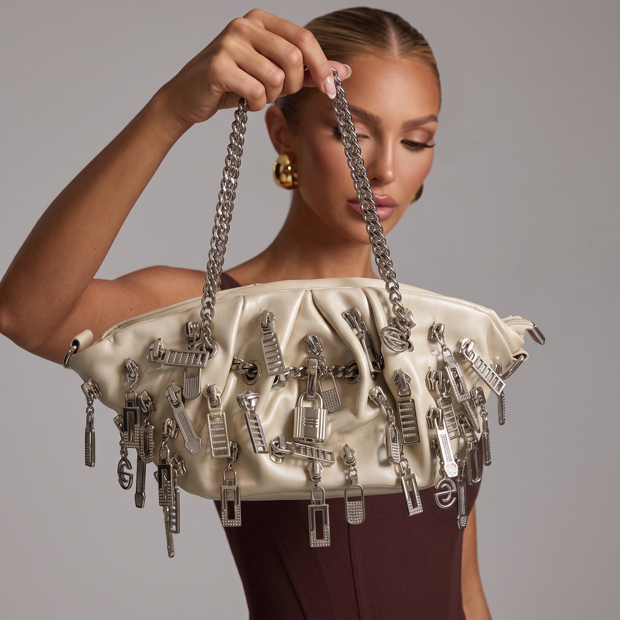 Ivory ruched tote bag with silver metal charms and braided chain handles
