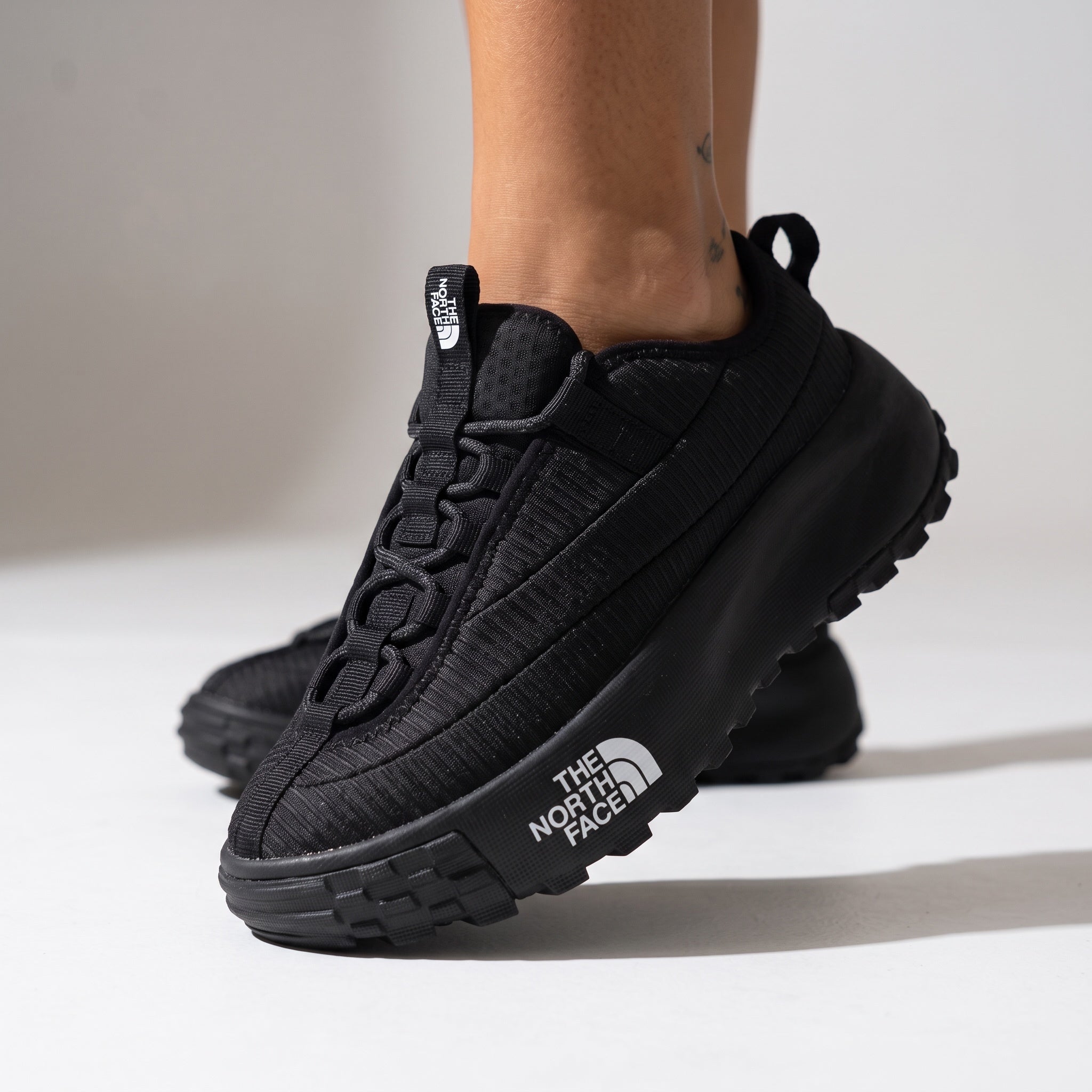 The North Face black trail sneaker with chunky lug sole and visible logo on midsole