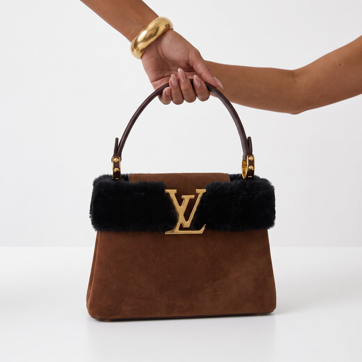 Brown suede top-handle bag with black fur trim and gold LV logo