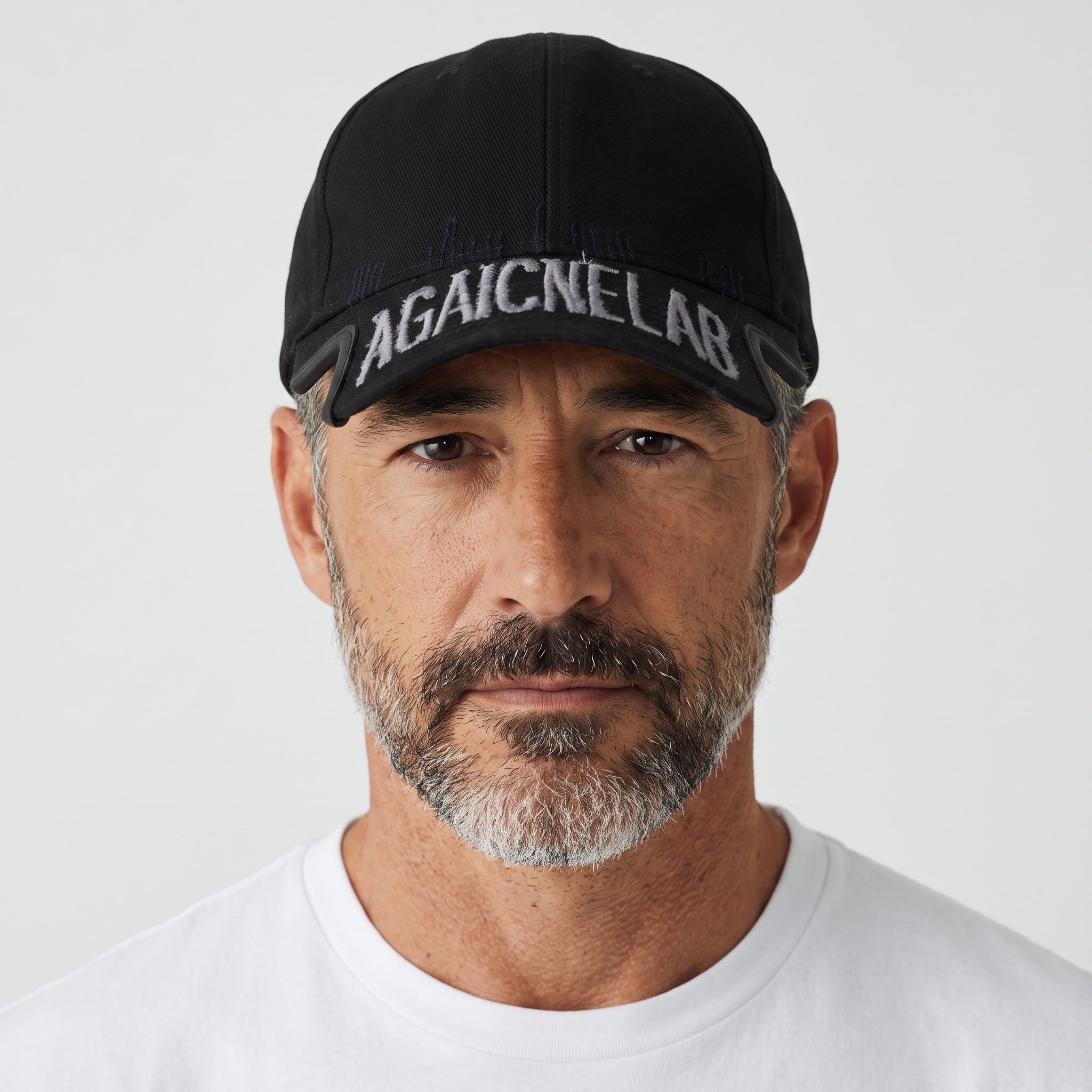 Man wearing a black baseball cap with embroidered white lettering on the brim