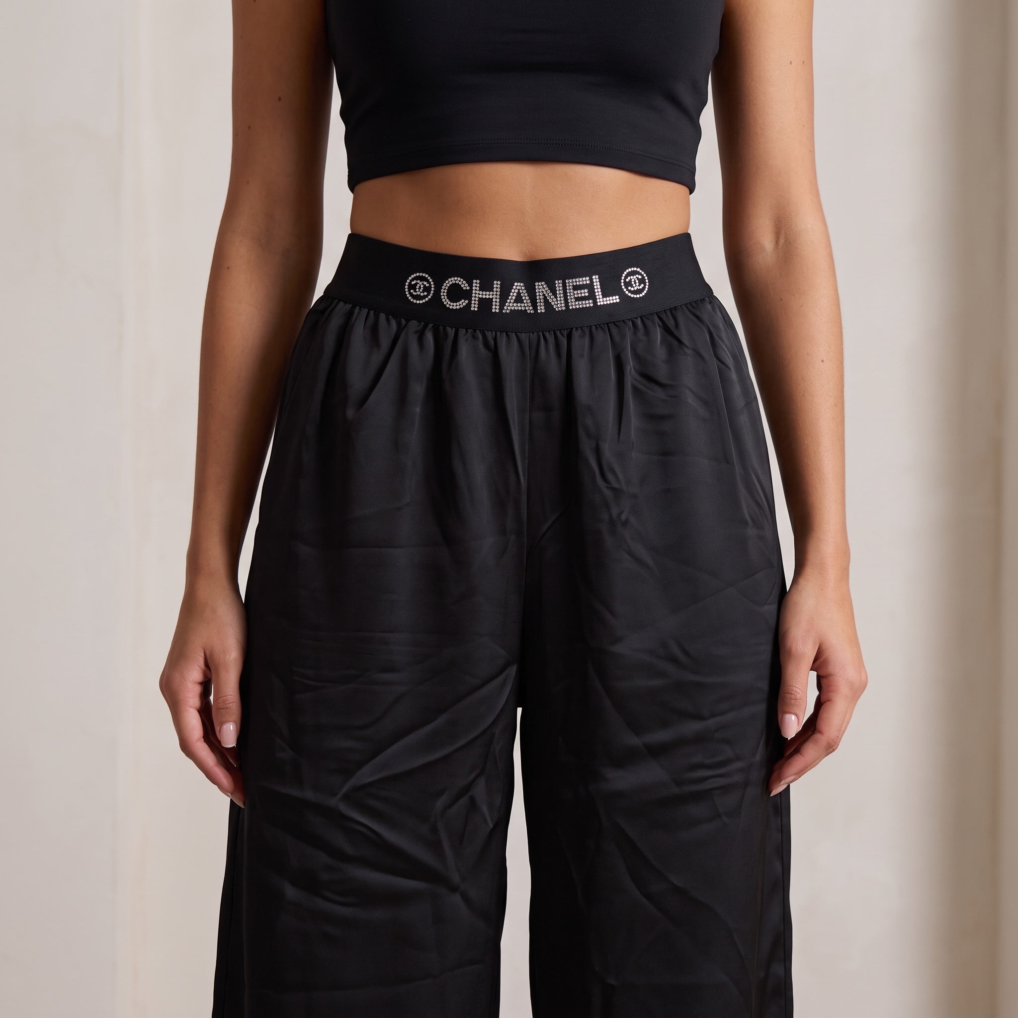 Black wide-leg trousers with high elastic waistband printed CHANEL logo in crystal dots