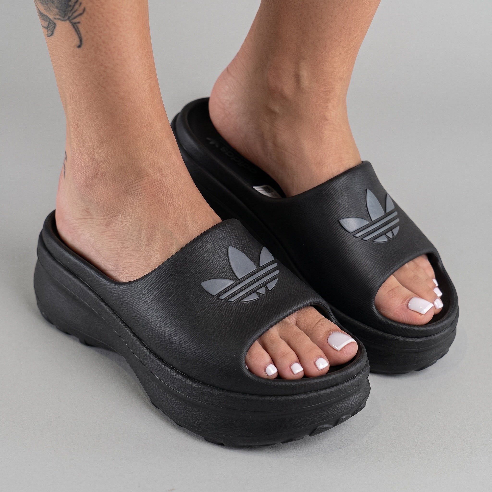 black adidas platform slide sandal with embossed trefoil