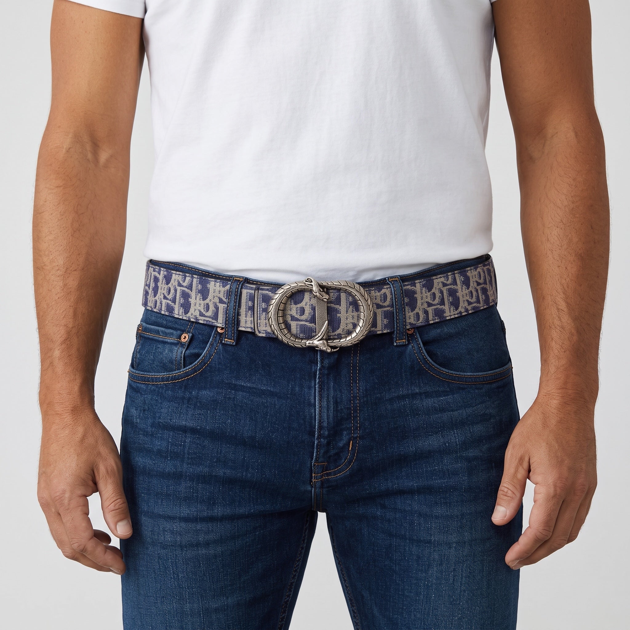 Blue logo jacquard belt with large serpent-style metal buckle worn with jeans