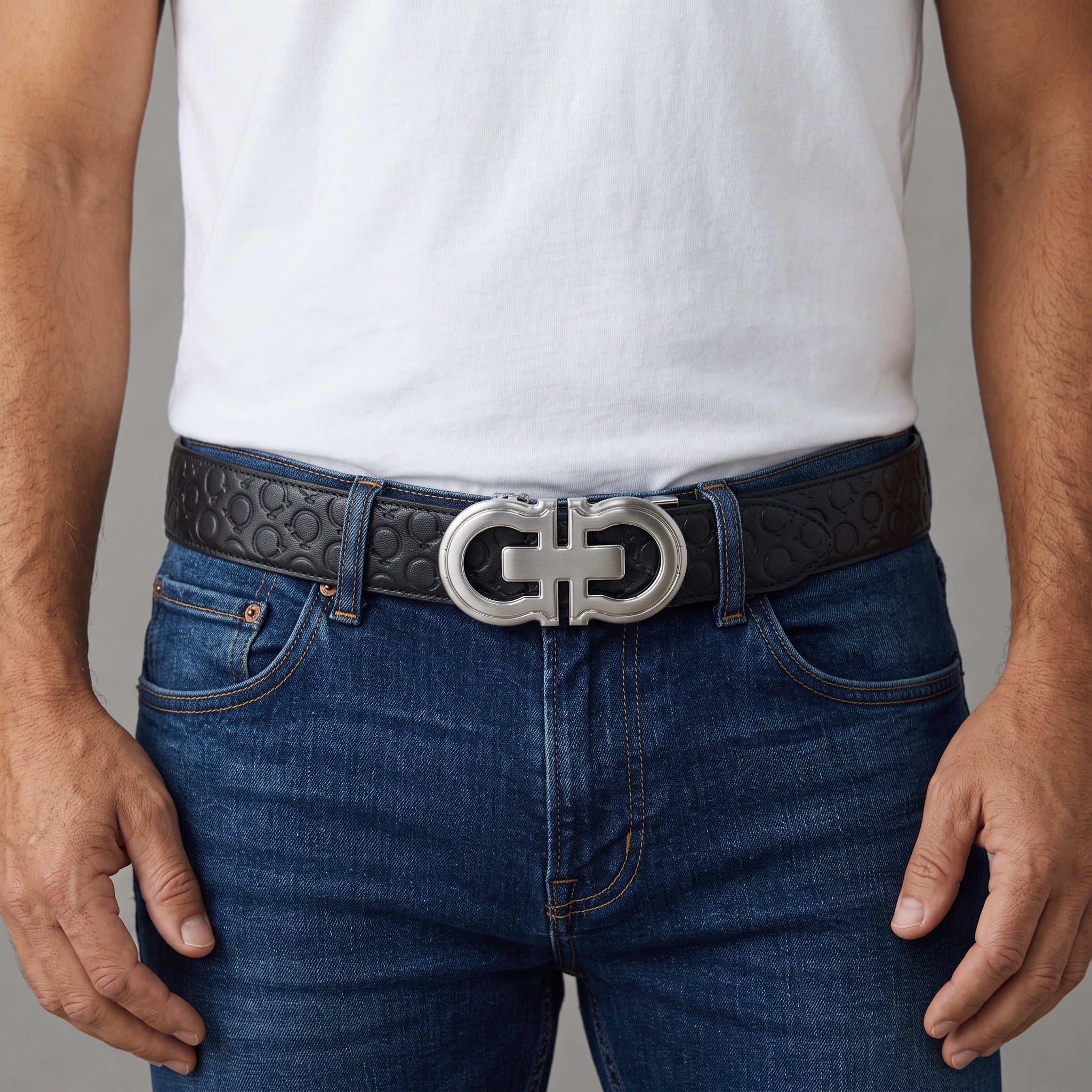 Close-up of a black Ferragamo belt with silver double Gancini buckle worn with jeans and white tee