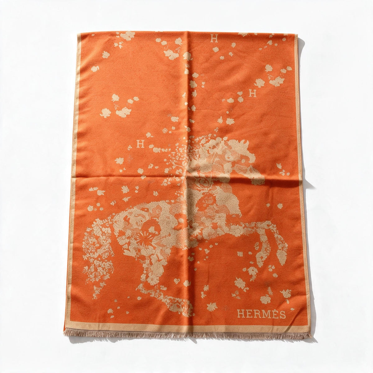 Orange Hermès scarf with floral motif, "H" logo and fringed edges