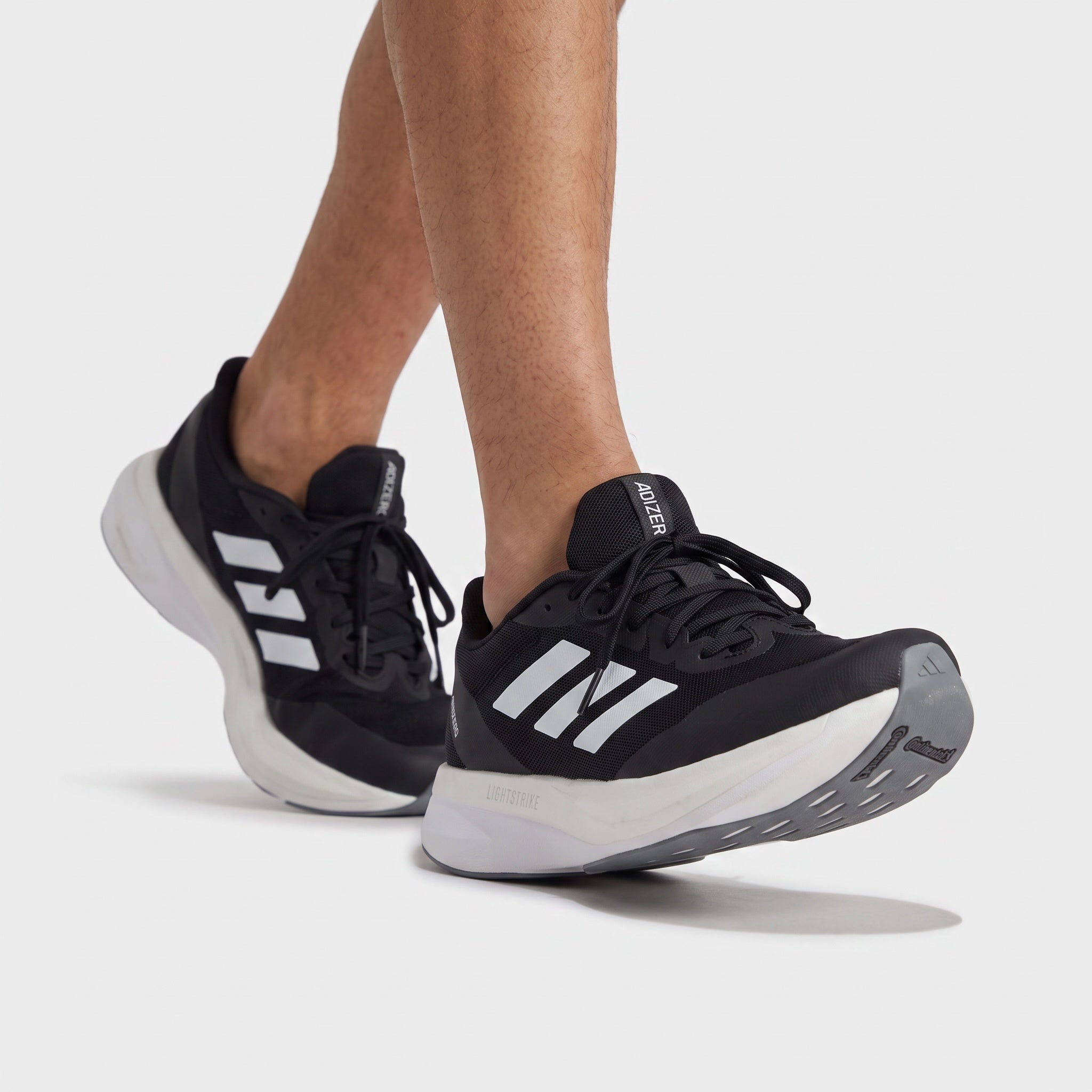 Black Adidas Adizero running sneaker with white midsole and three stripes