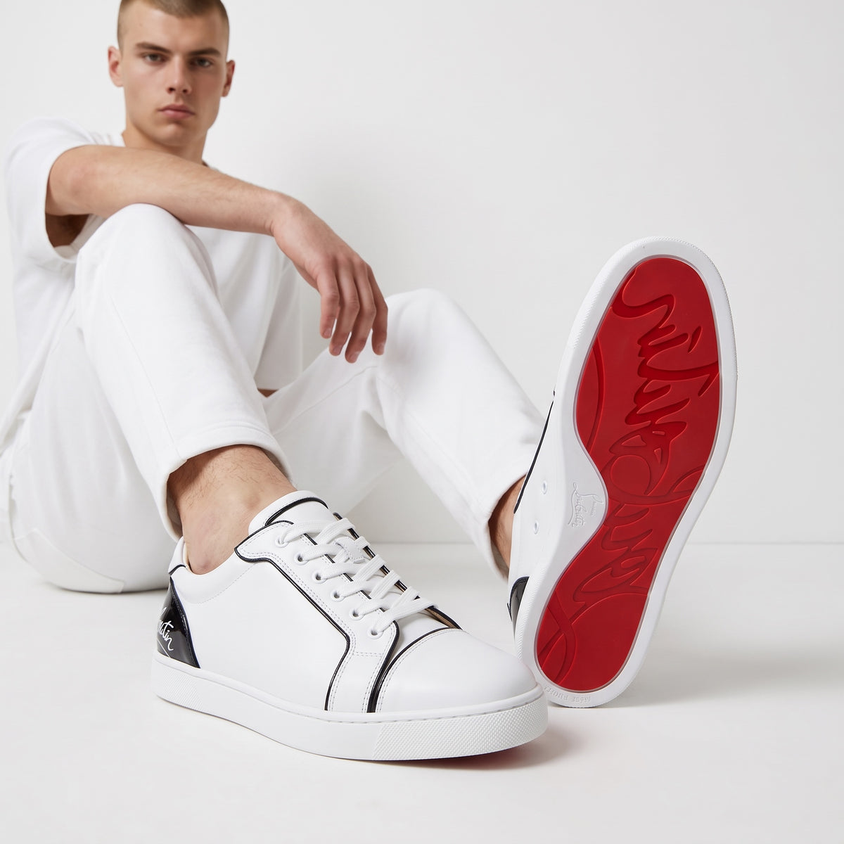 Christian Louboutin white low-top sneakers with black heel tab and red sole