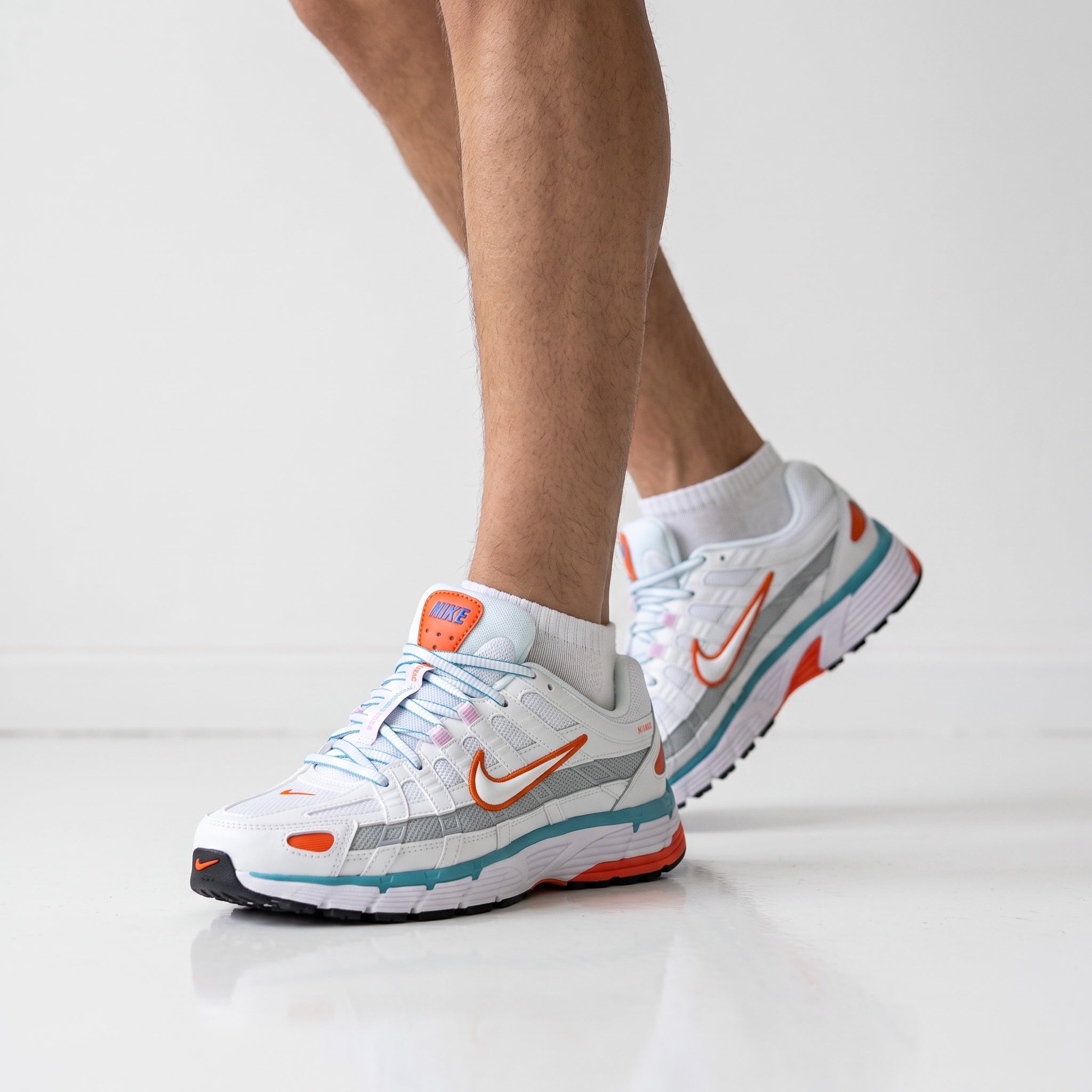 Nike P-6000 white sneakers with orange and teal accents