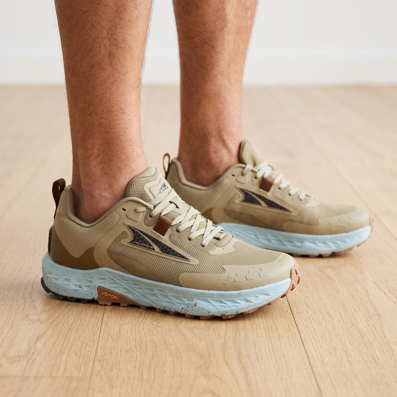 Altra tan trail running shoe with light blue midsole and Vibram sole