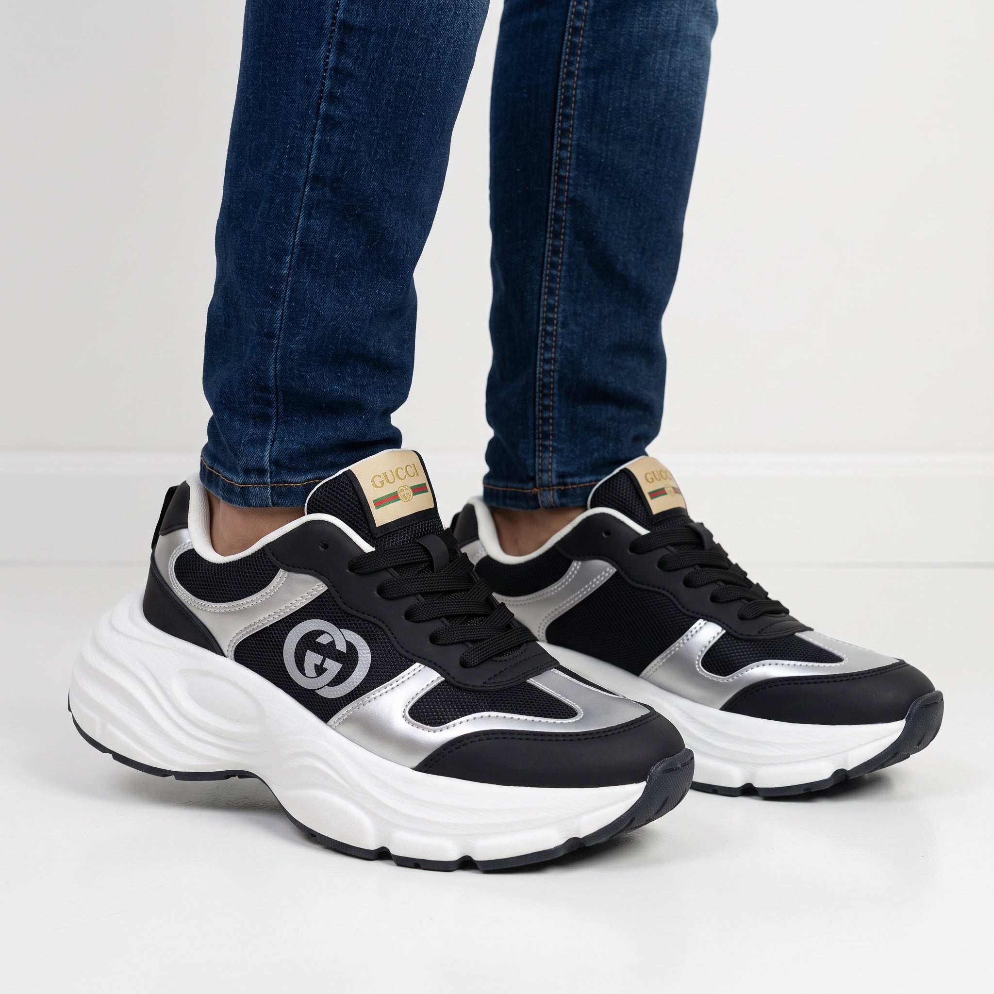 Gucci black and silver chunky sneakers with white sole and visible GG logo on side and tongue